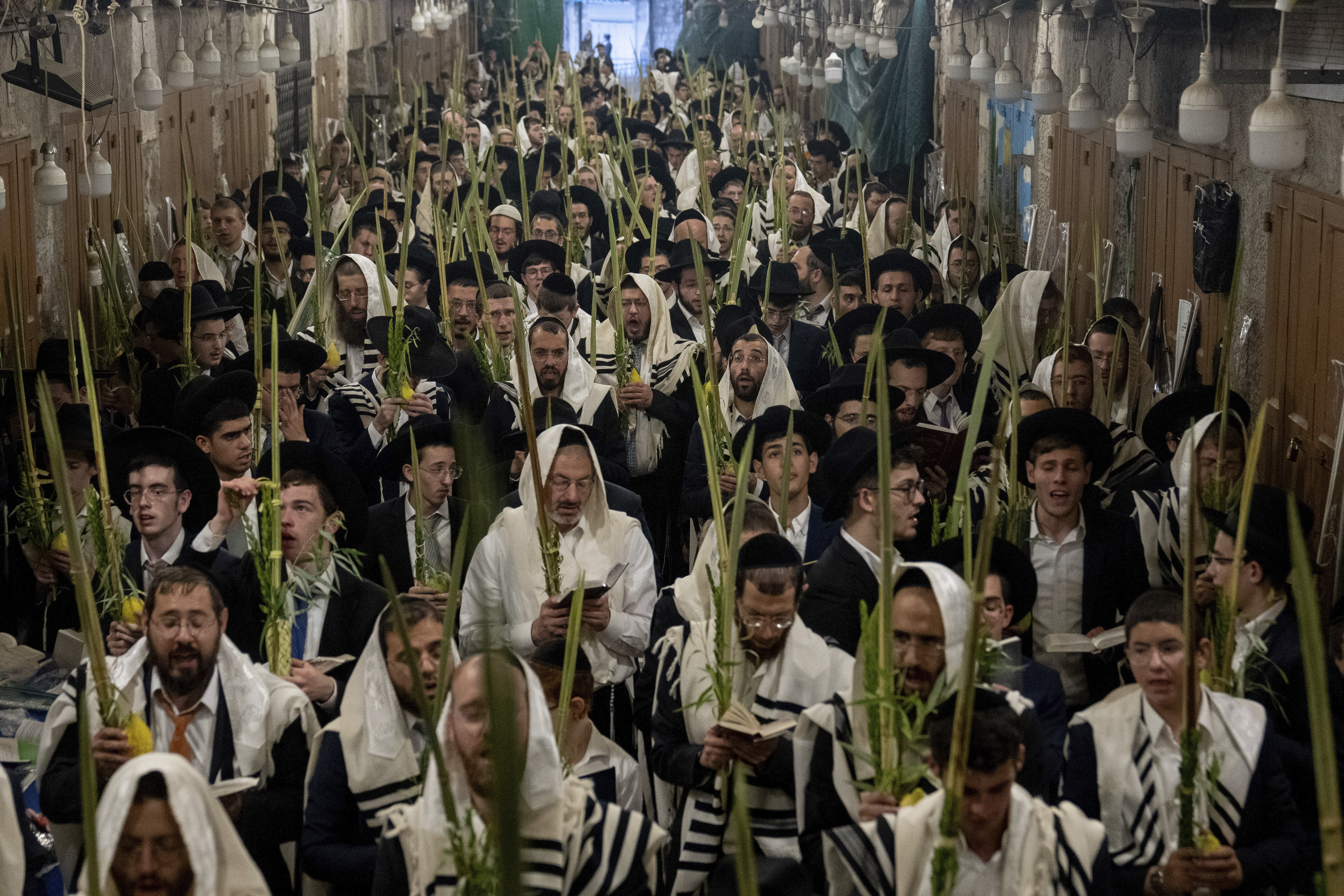 Jewish worshippers pray during the weeklong Jewish holiday of Sukkot, next to one of the gates to the Temple Mount, known to Muslims as the Noble Sanctuary, or the Al-Aqsa Mosque compound, in the Old City of Jerusalem, Wednesday, Oct. 4, 2023. (AP Photo/Ohad Zwigenberg)