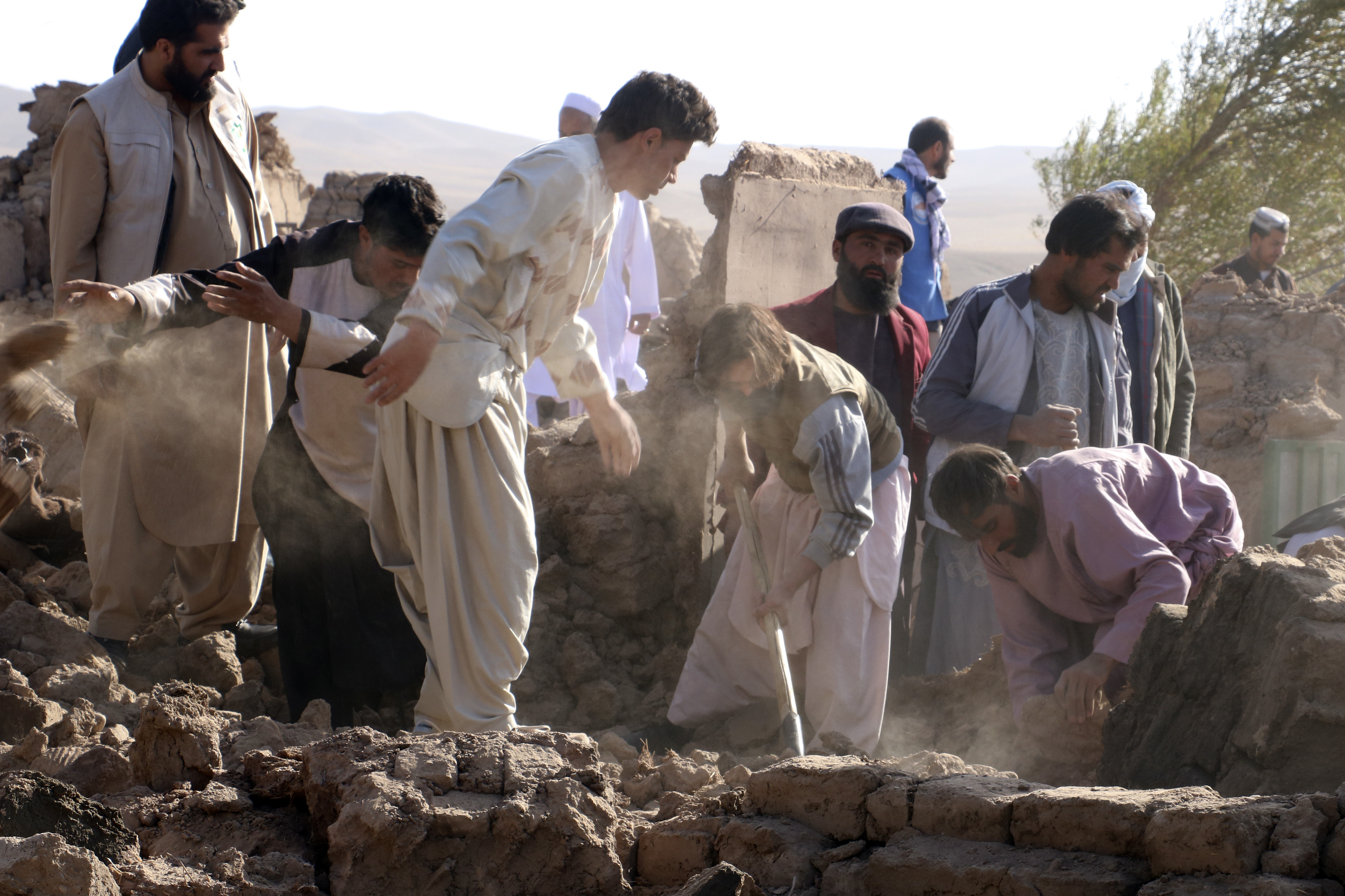 Afghan men search for victims after an earthquake in Zenda Jan district in Herat province, of western Afghanistan