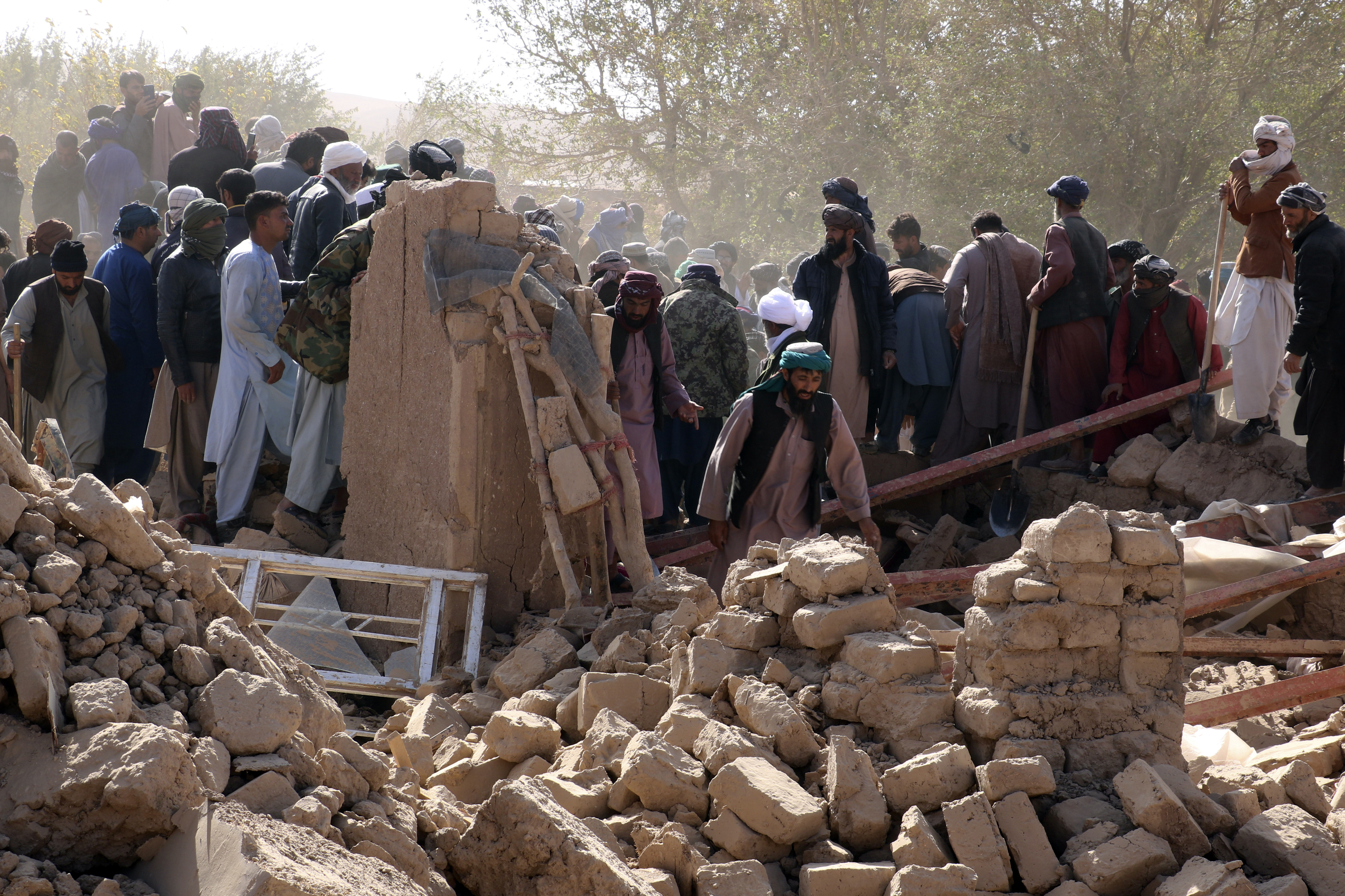 Afghan men search for victims after an earthquake in Zenda Jan district in Herat province, of western Afghanistan