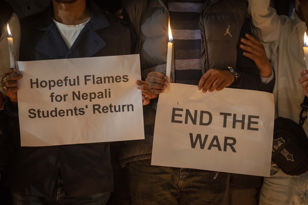 Students hold placards demanding Nepalese government ensure the safe return of stranded students and light candles in Patan Durbar Square, Lalitpur, Nepal, as they pay tribute to Nepali nationals who lost their lives in the fighting in Israel, Monday, Oct. 9, 2023. Ten Nepali nationals have been killed in fighting in Israel and at least one more is missing, Nepal’s Foreign Ministry said. An unknown number of others were wounded in the violence, it added. (AP Photo/Niranjan Shrestha)
