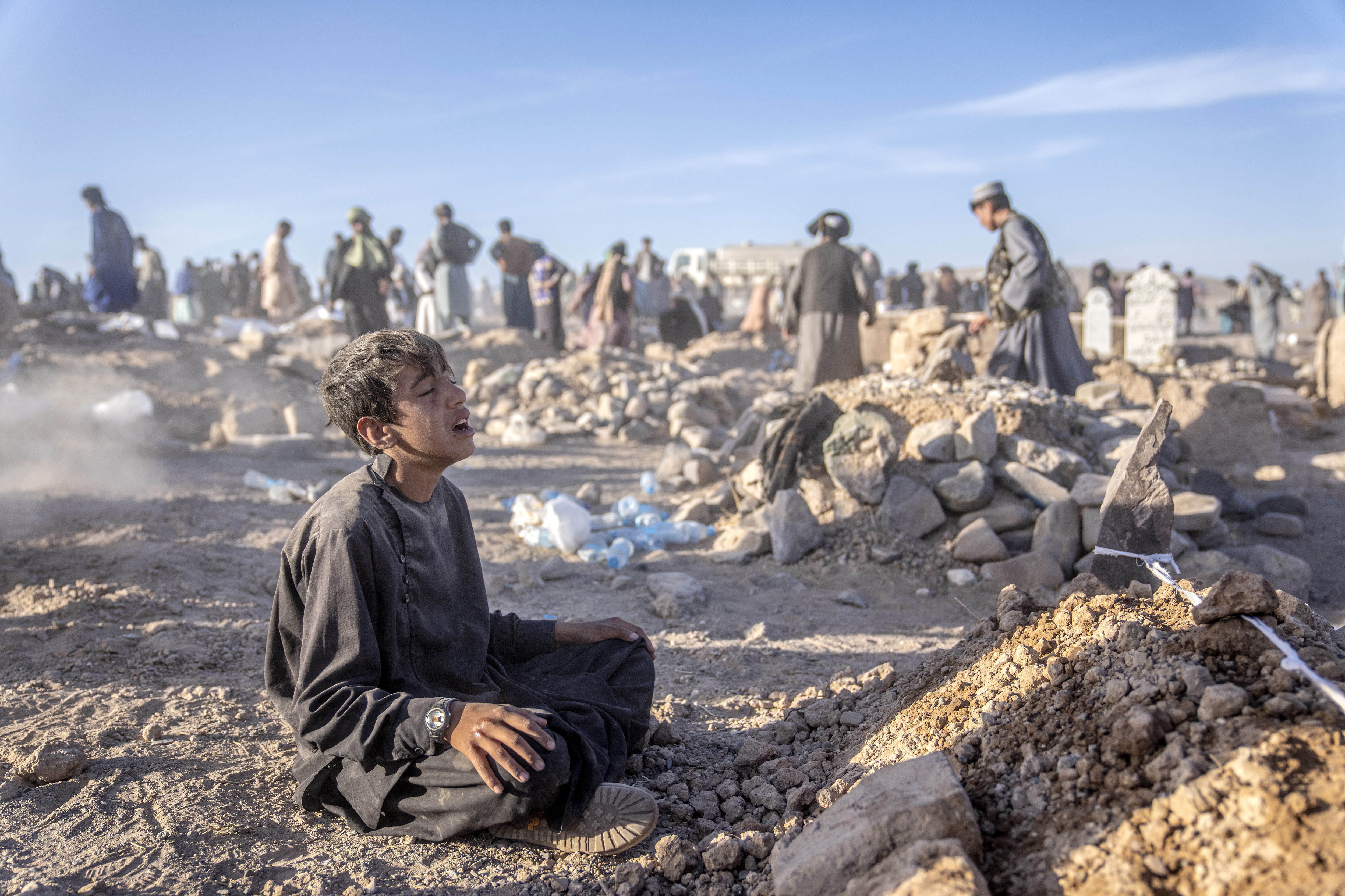 An Afghan boy mourns next to the grave of his little brother who died due to an earthquake, in Zenda Jan district in Herat province, western of Afghanistan, Monday, Oct. 9, 2023. Saturday's deadly earthquake killed and injured thousands when it leveled an untold number of homes in Herat province. (AP Photo/Ebrahim Noroozi)