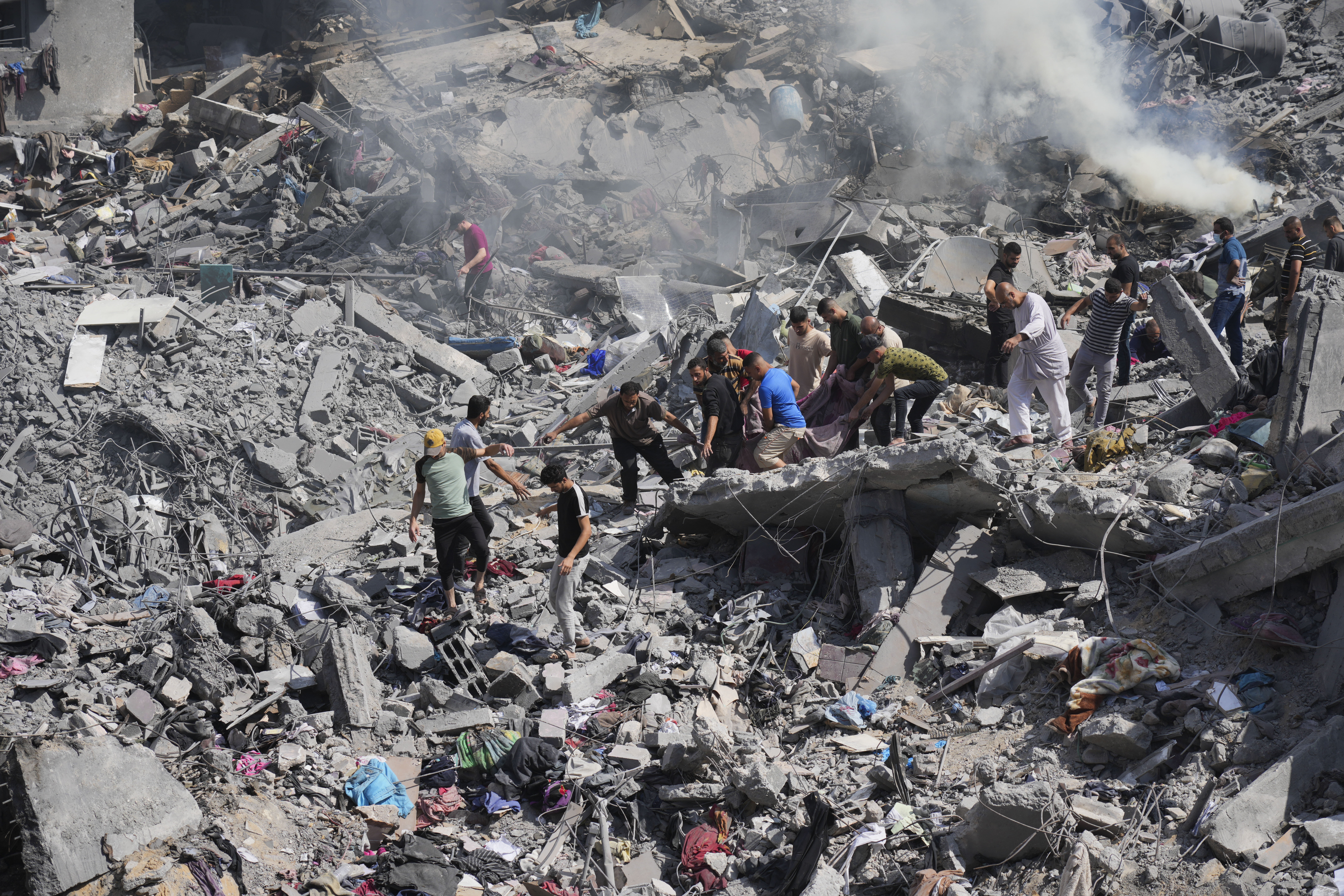 Palestinians pull dead from the building destroyed in an Israeli airstrike in Bureij refugee camp Gaza Strip