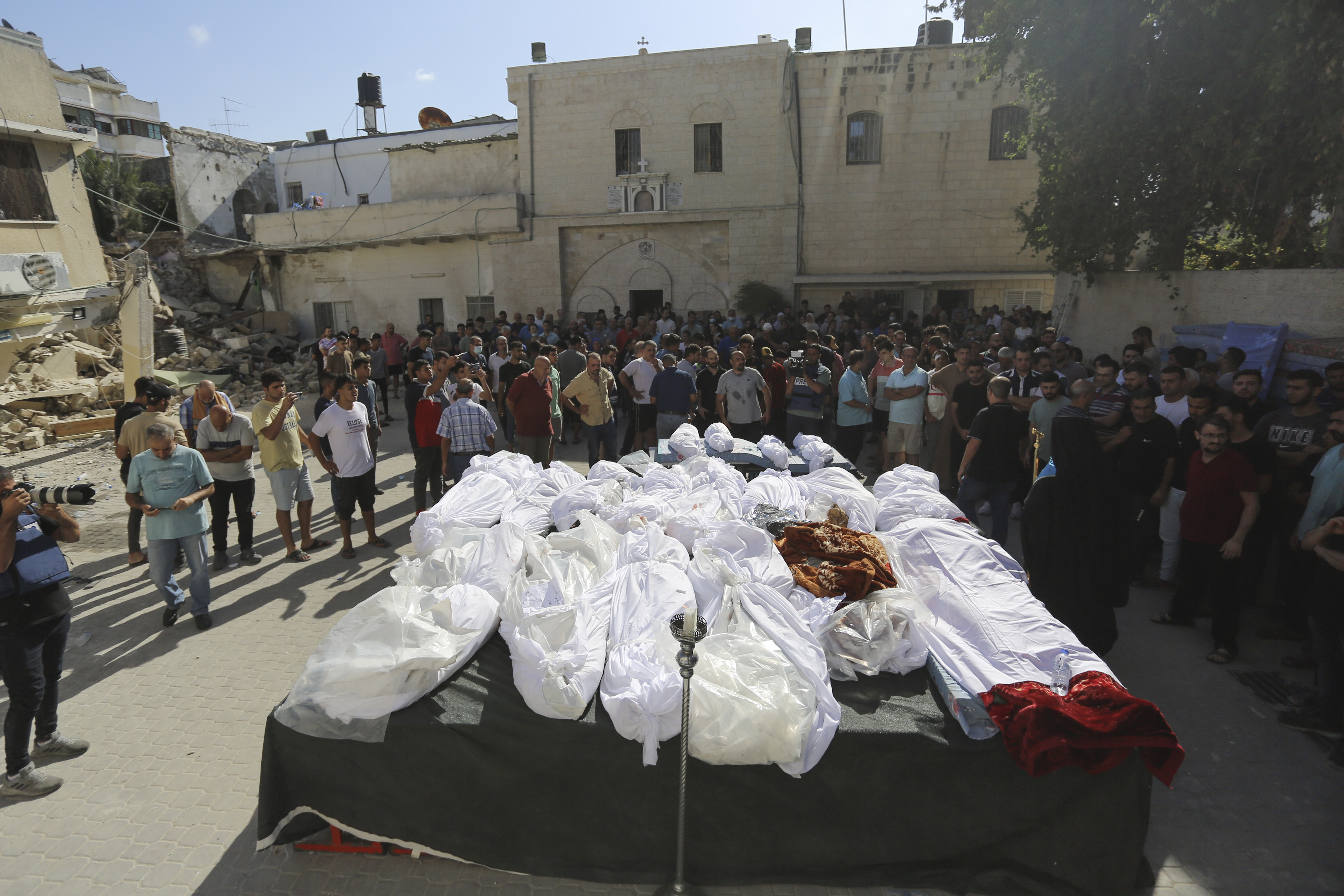 Relatives attend the funeral of Palestinians who were killed in Israeli airstrikes that hit a church, in Gaza City