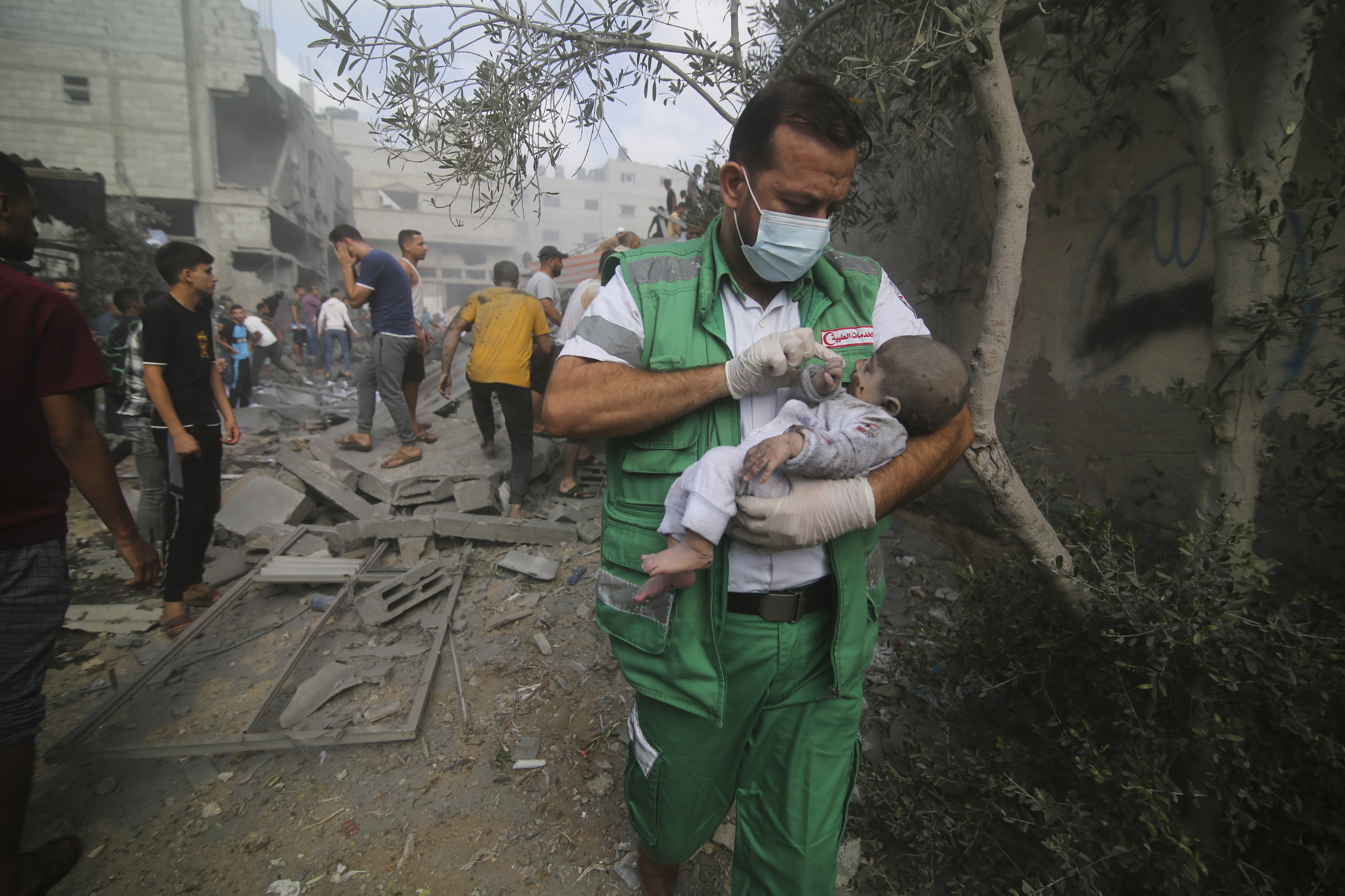 Palestinian medic takes a baby pulled out of buildings destroyed in the Israeli bombardment of the Gaza Strip in Rafah