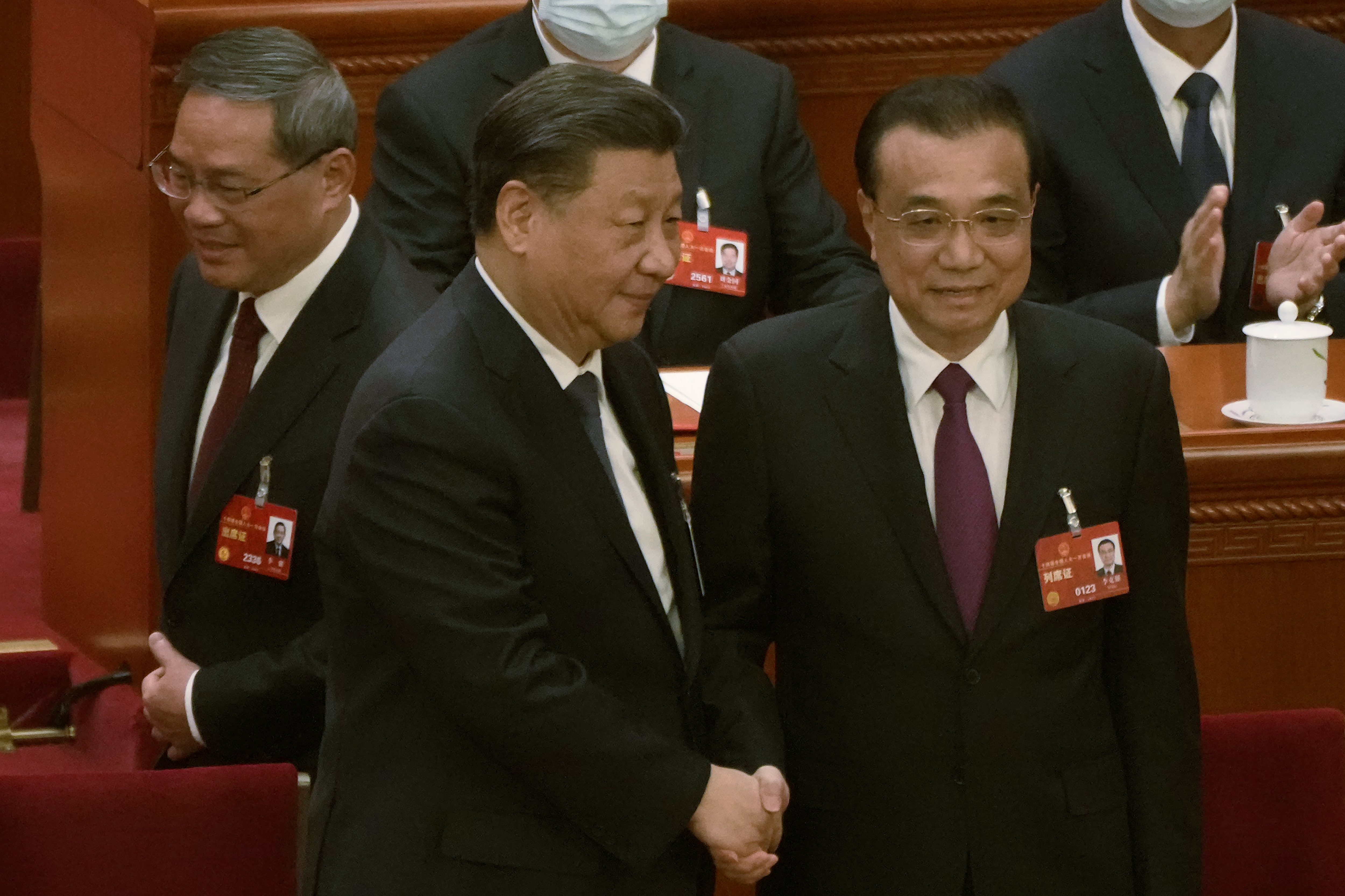 Li Keqiang and Xi Jinping shaking hands at the March congress when Li retired.