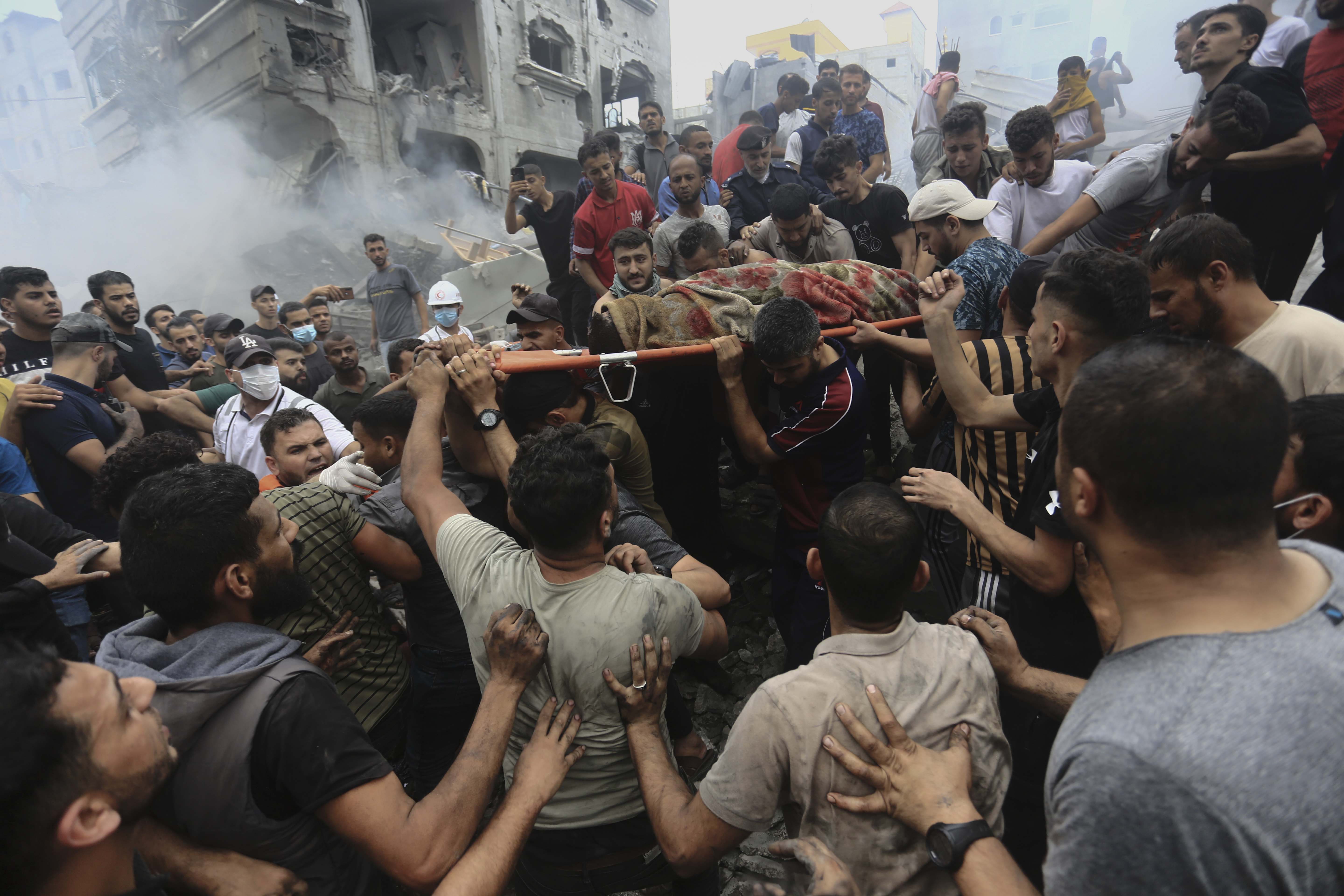 Palestinians remove a dead body from the rubble of a building after an Israeli airstrike Jebaliya refugee camp, Gaza Strip
