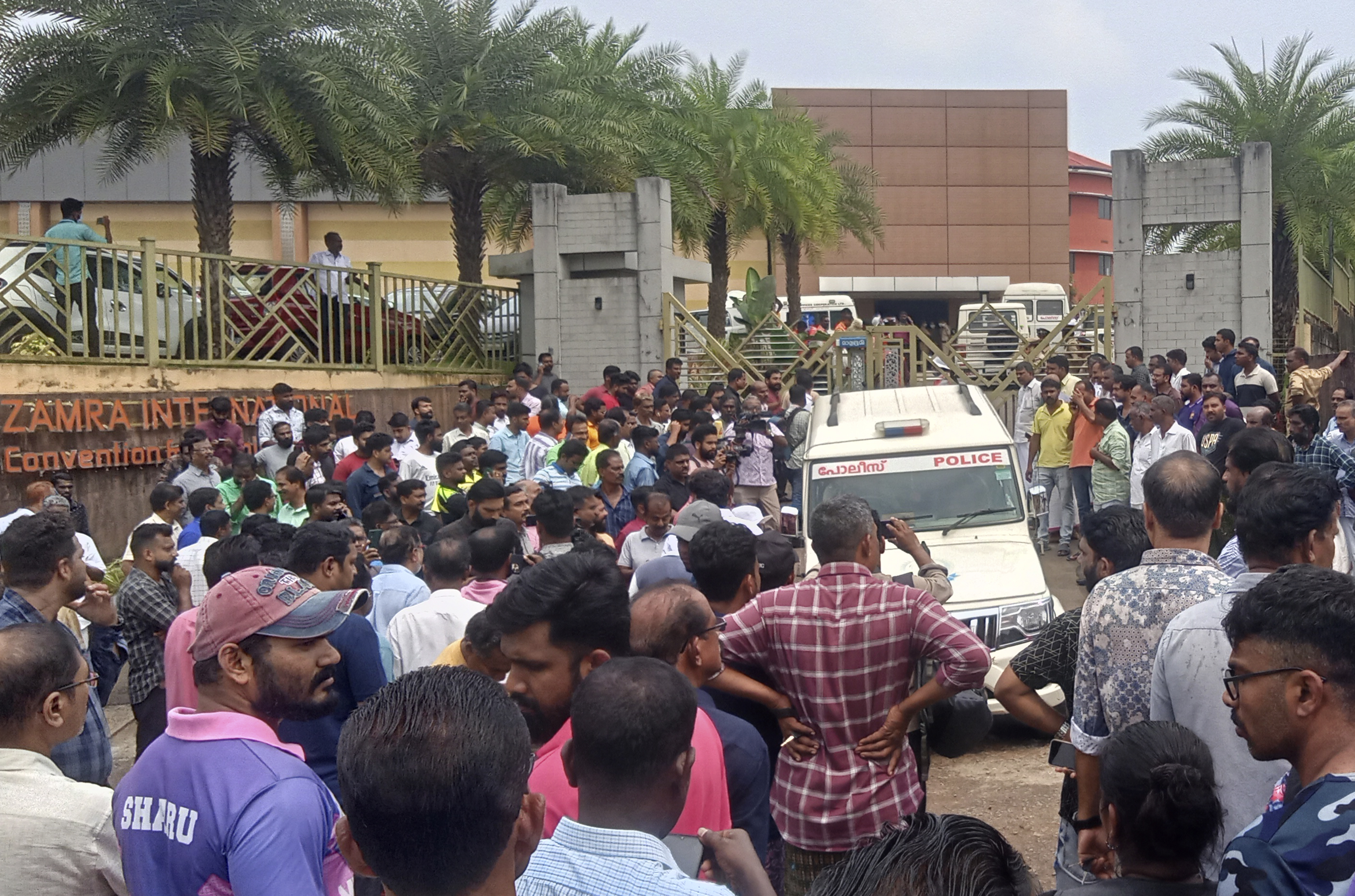 People gather outside following a blast at the Zamra convention center in Kalamassery, a town in Kochi, India