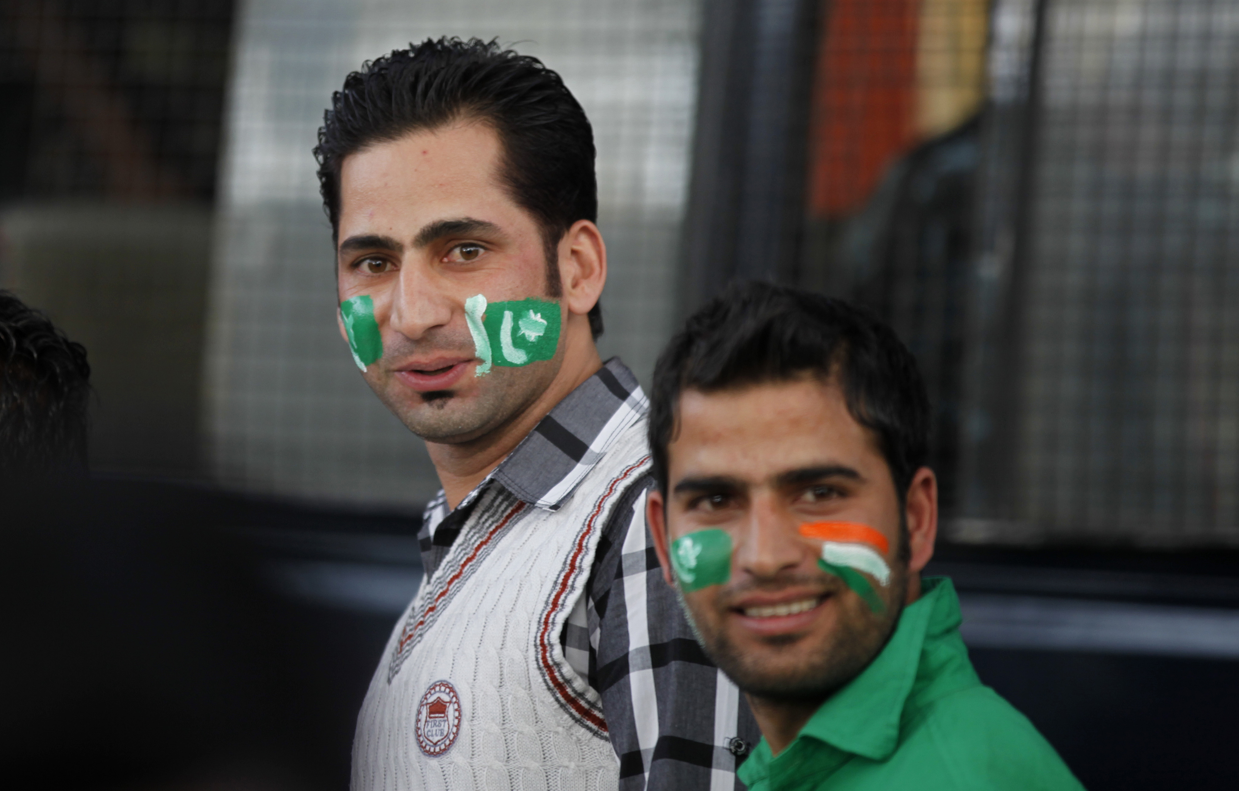 Fans of Pakistan cricket team react to the camera as they wait to get inside the Chinnaswamy Stadium, the venue of first Twenty20 cricket match between India and Pakistan, in Bangalore, India, Tuesday, Dec. 25, 2012