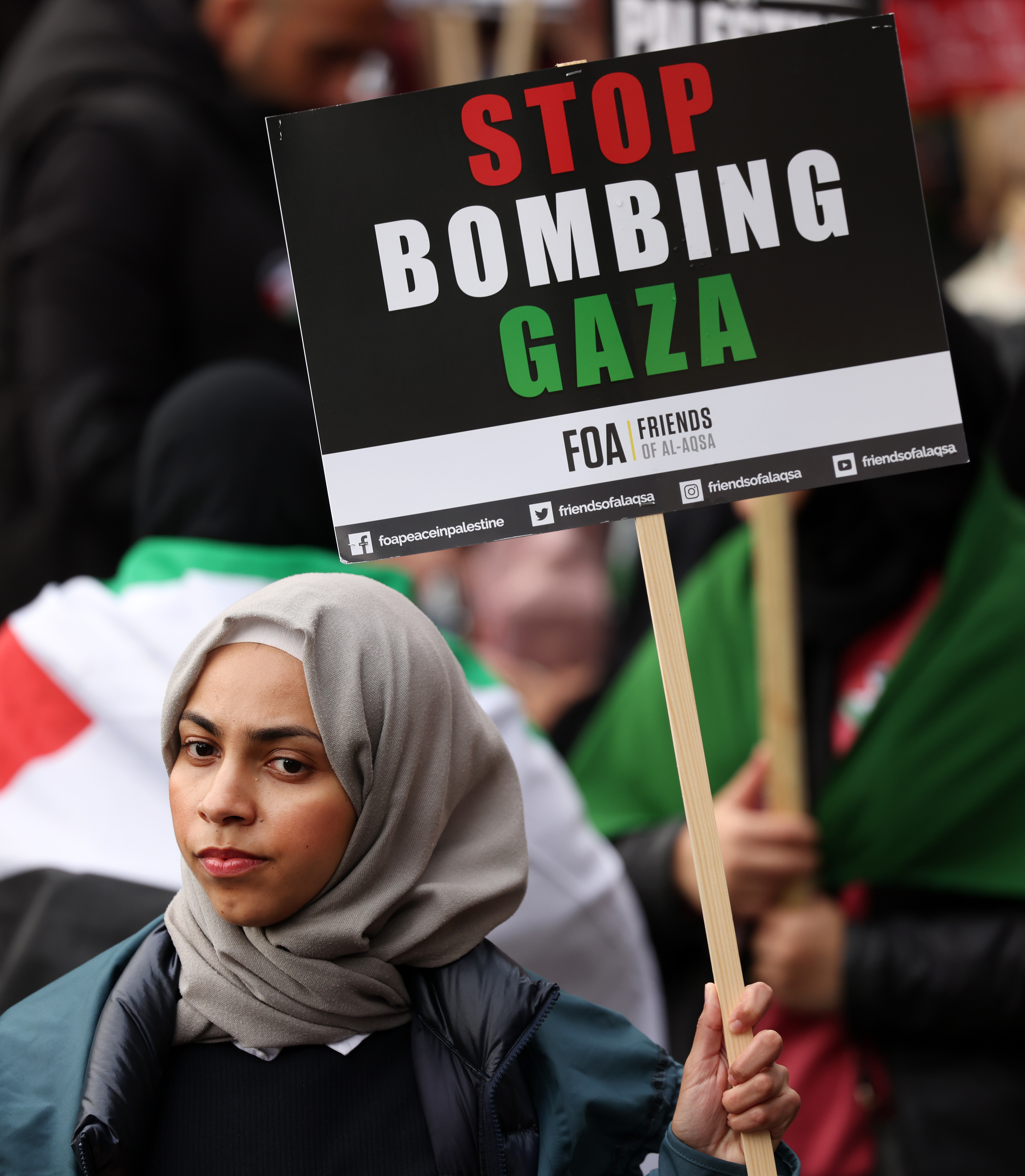 A pro-Palestinian protester holds a placard on a march through the British capital during a demonstration for the Palestinian people, in London, Britain, 21 October 2023. [EPA-EFE/Andy Rain]