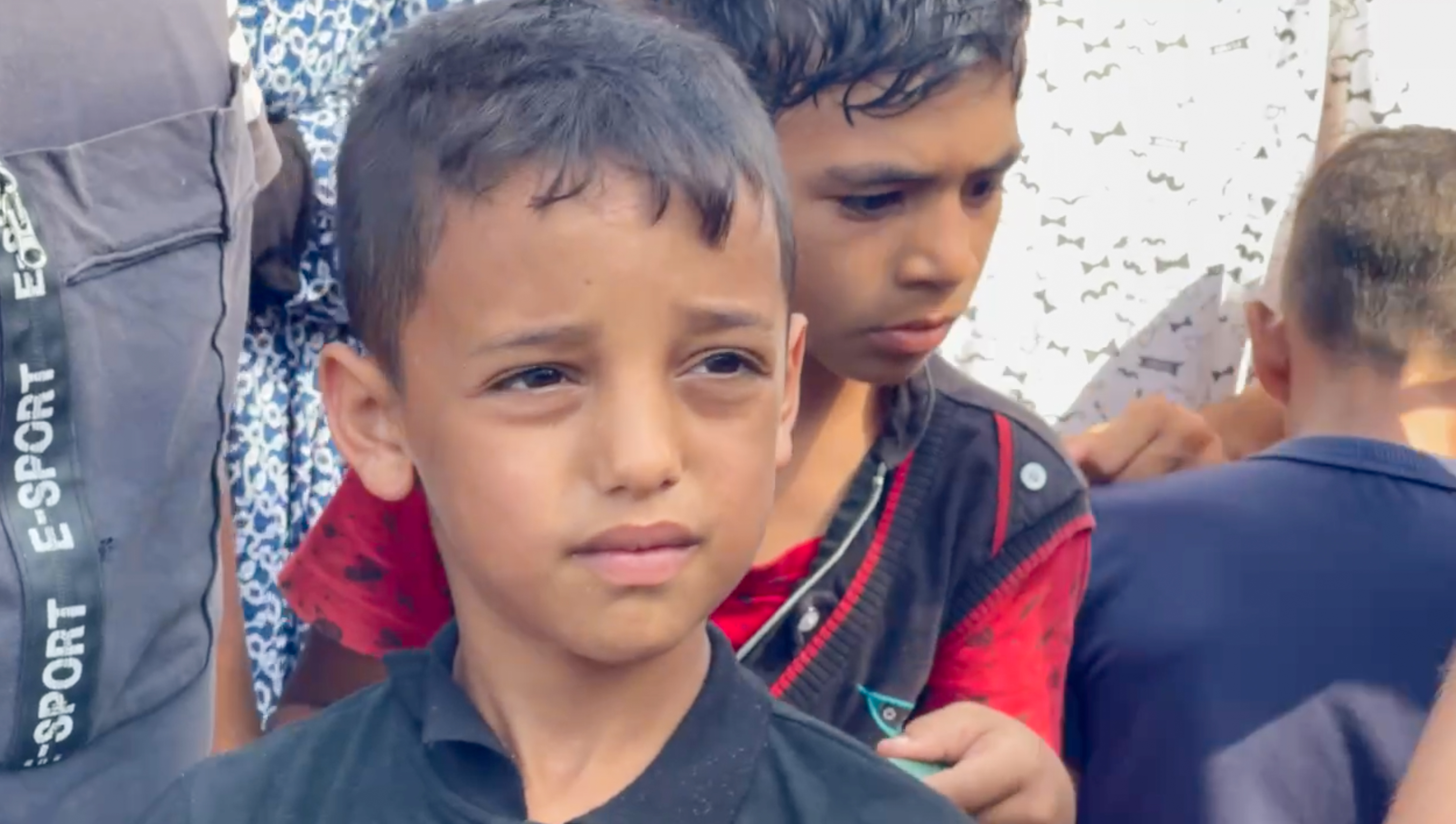 Children carry pots and metal bowls for a serving of rice and beans 