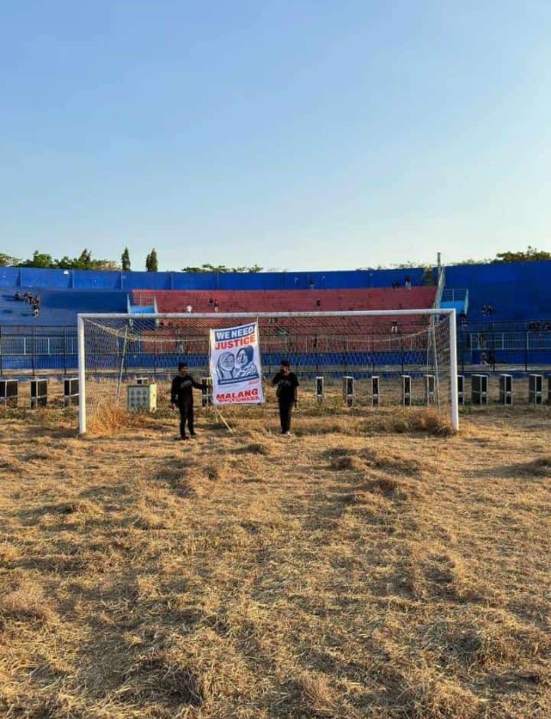 Devi Ahok hangs a banner with his daughter’s photos between the goal posts at the stadium. 