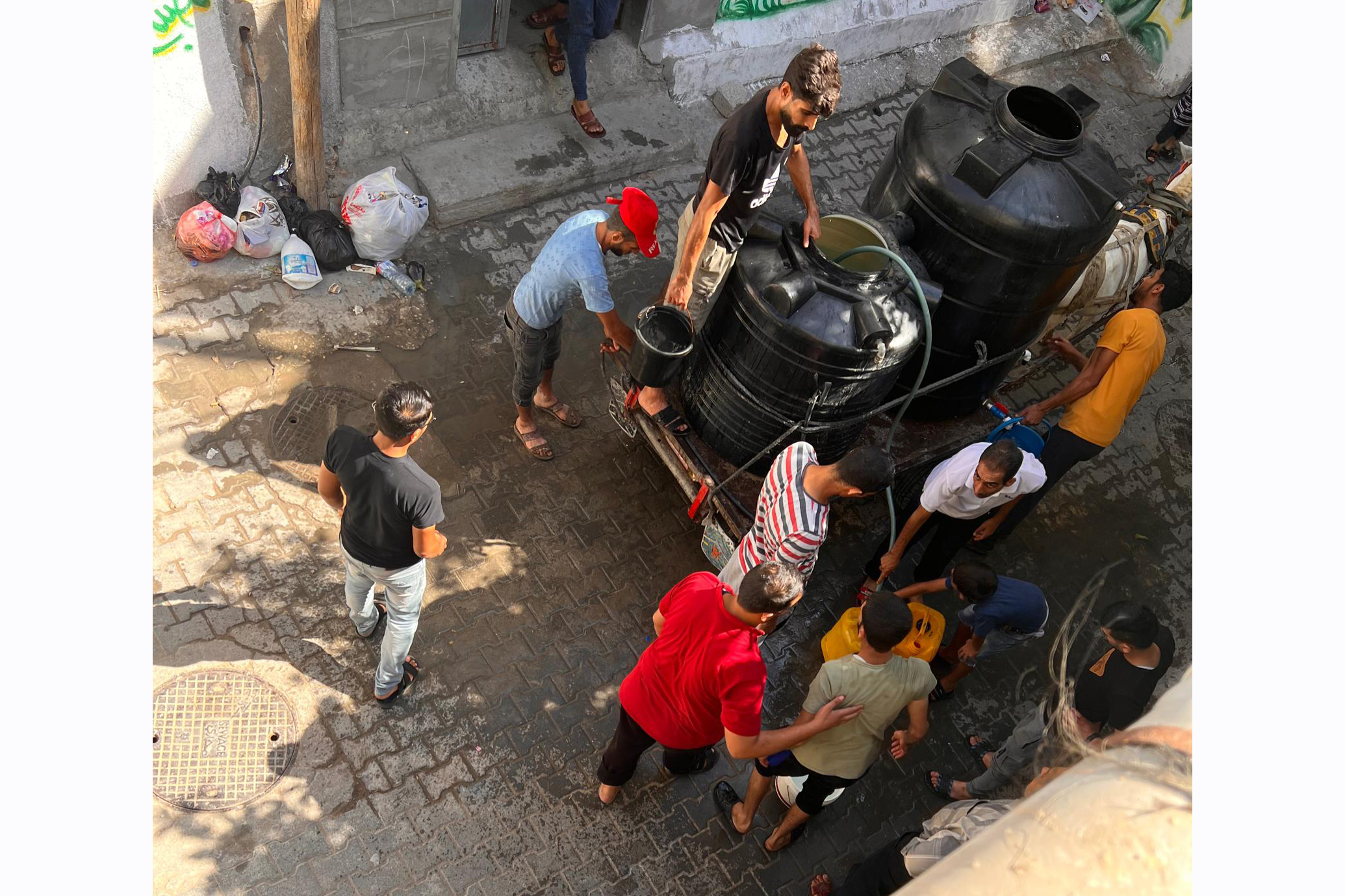 People with a donkey cart distributing water for those in need