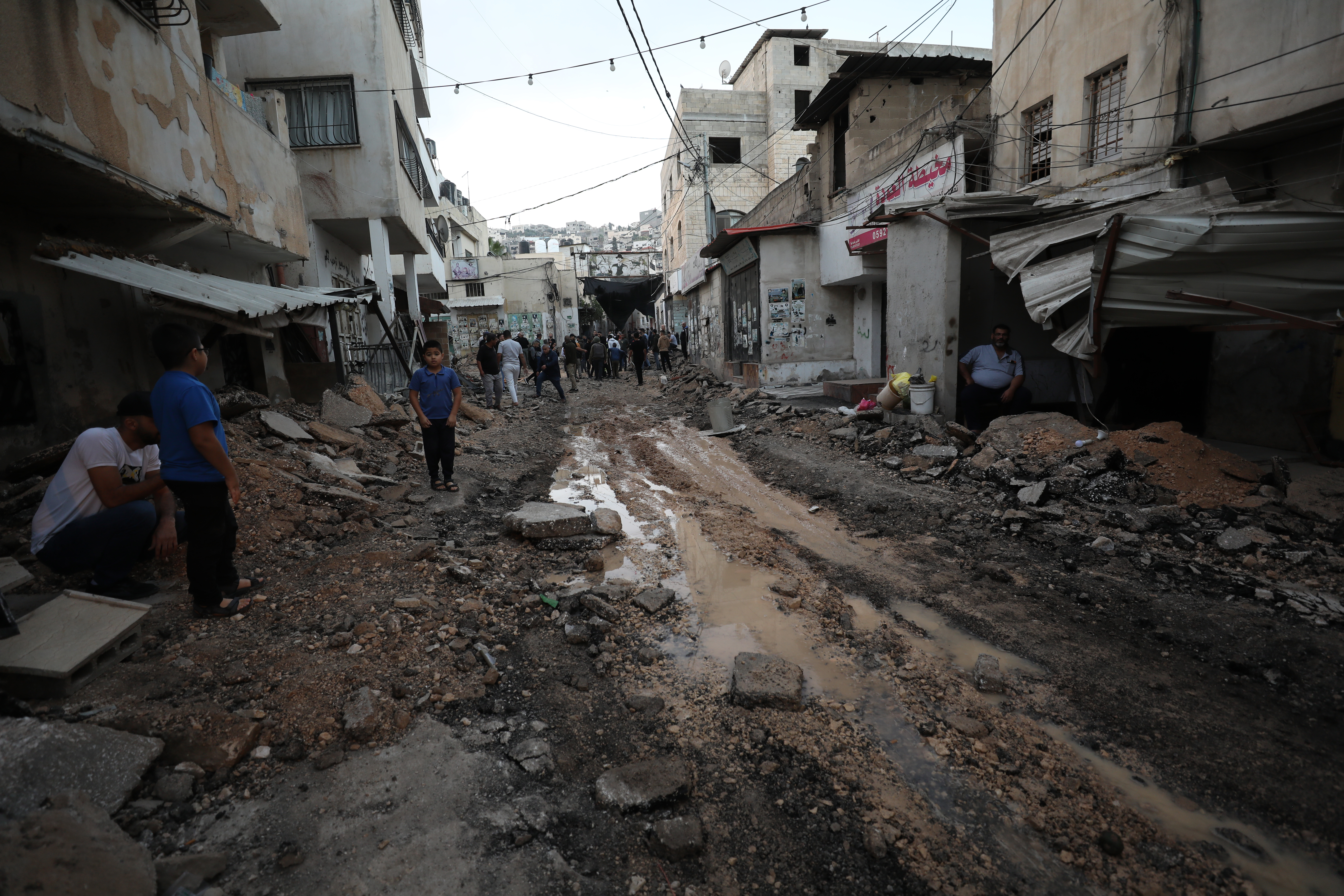 Palestinians inspect a damaged area inside the Jenin refugee camp following an Israeli raid, in the West Bank city of Jenin.