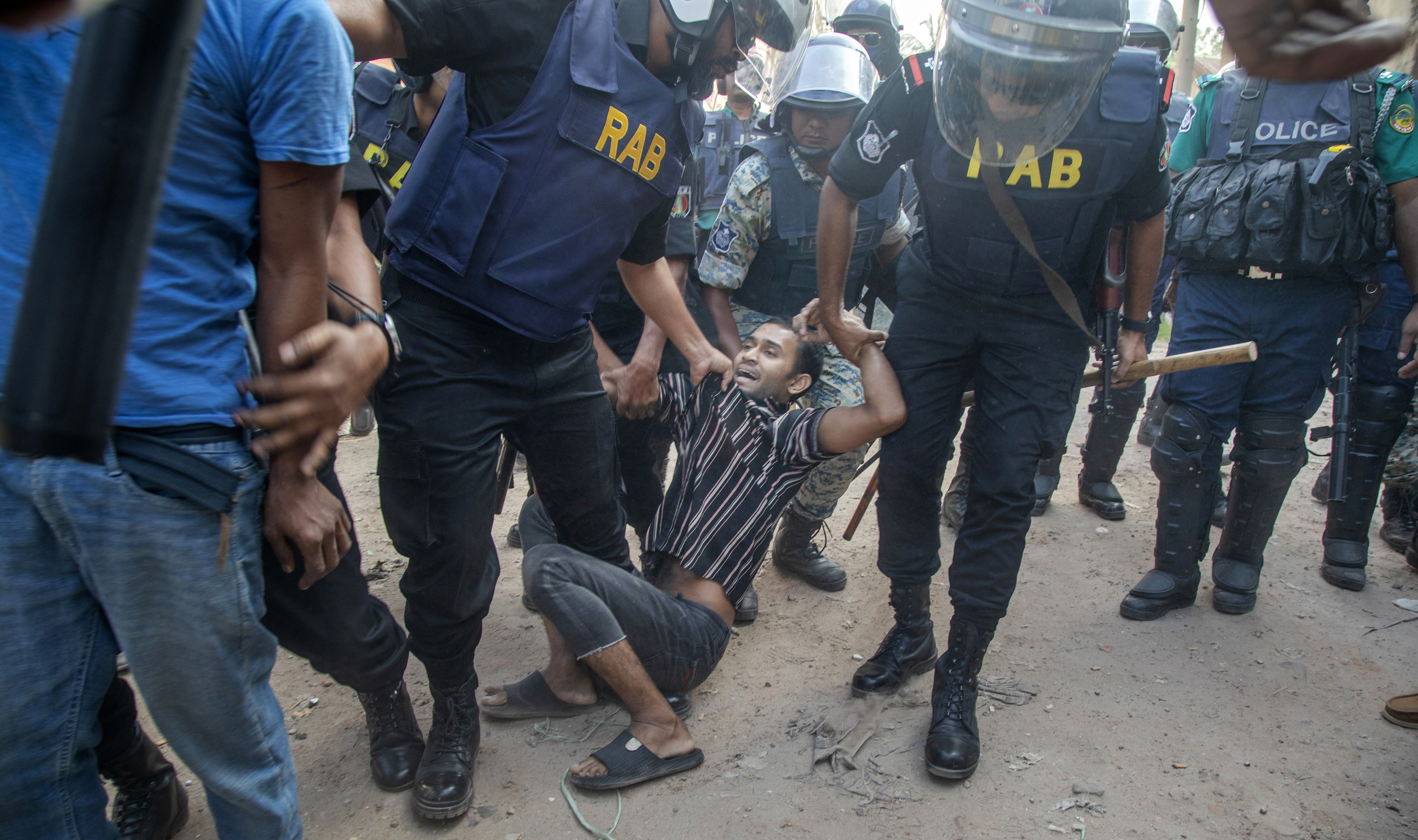 Bangladesh Rapid Action Battalion (RAB) members detain a garment worker during clashes in Gazipur city, on the outskirts of Dhaka, Bangladesh.