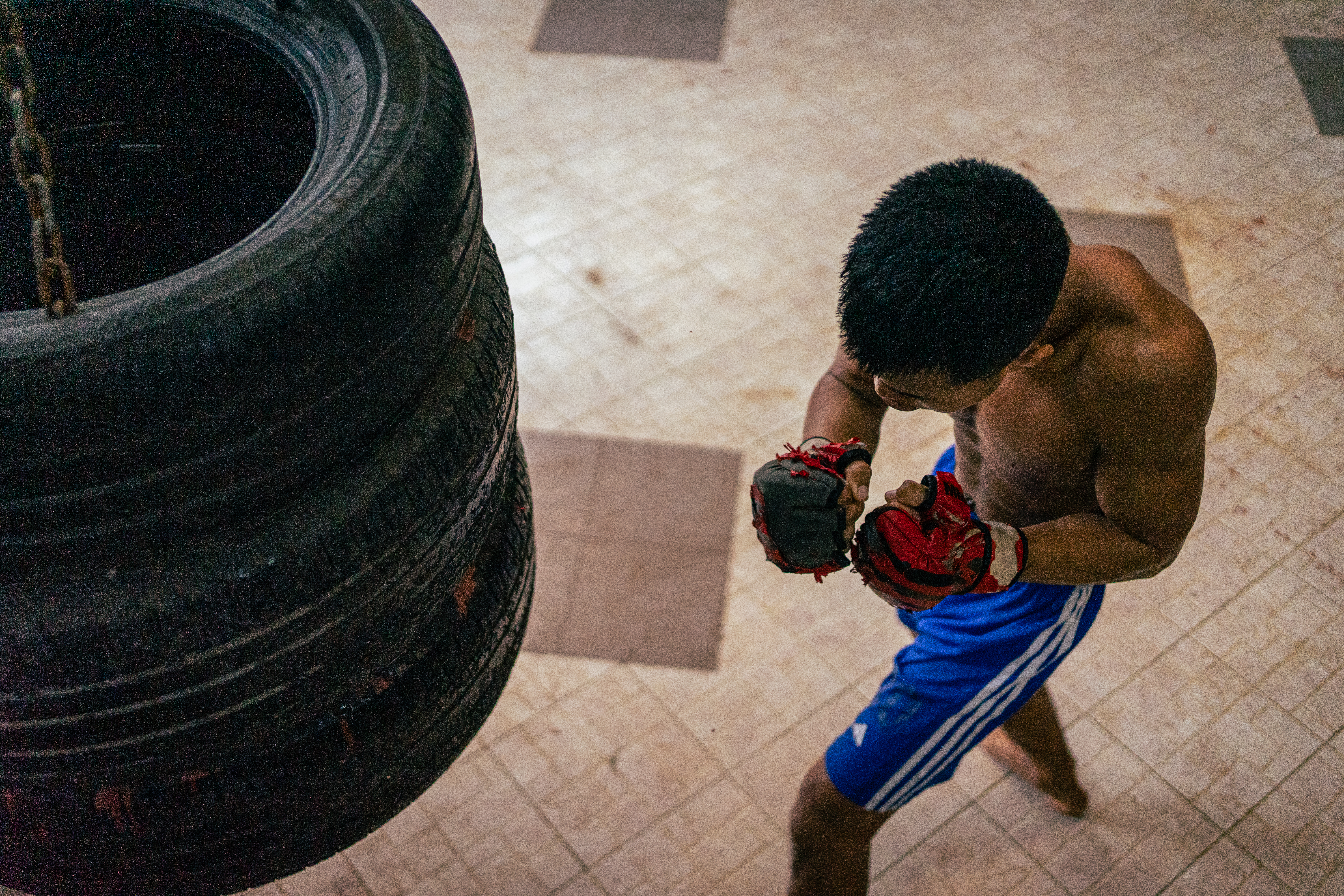 Than Phyo Zaw, 23, practices his jabs against three stacked car tyres at Power Punch.