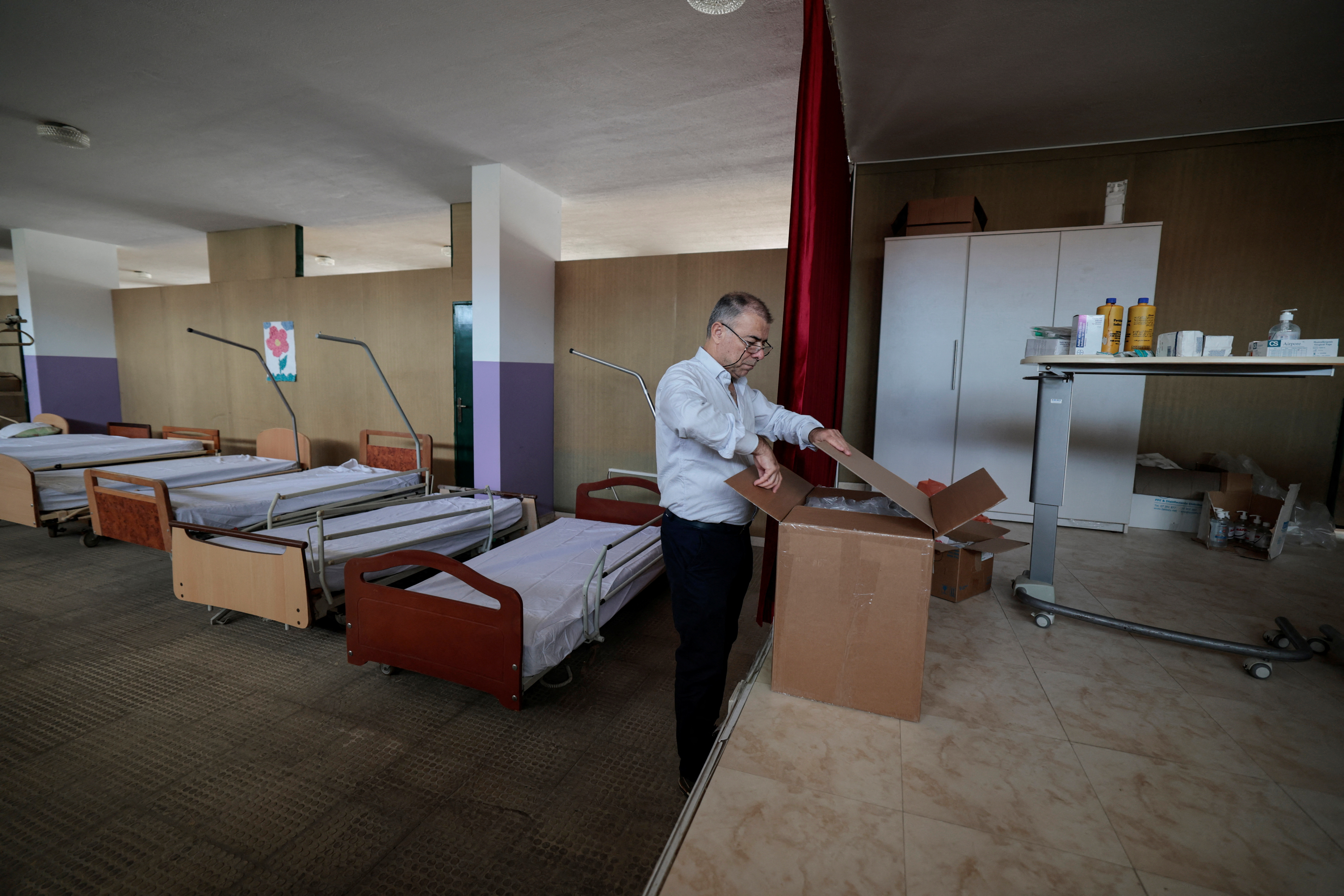 Doctor Georges Madi, opens a box of medical supplies at the field hospital, set up by locals near the Lebanese-Israeli border to give first aid treatment to those potentially injured, amidst tension between Israel and Hezbollah at the Christian village of Rmeish, Lebanon.
