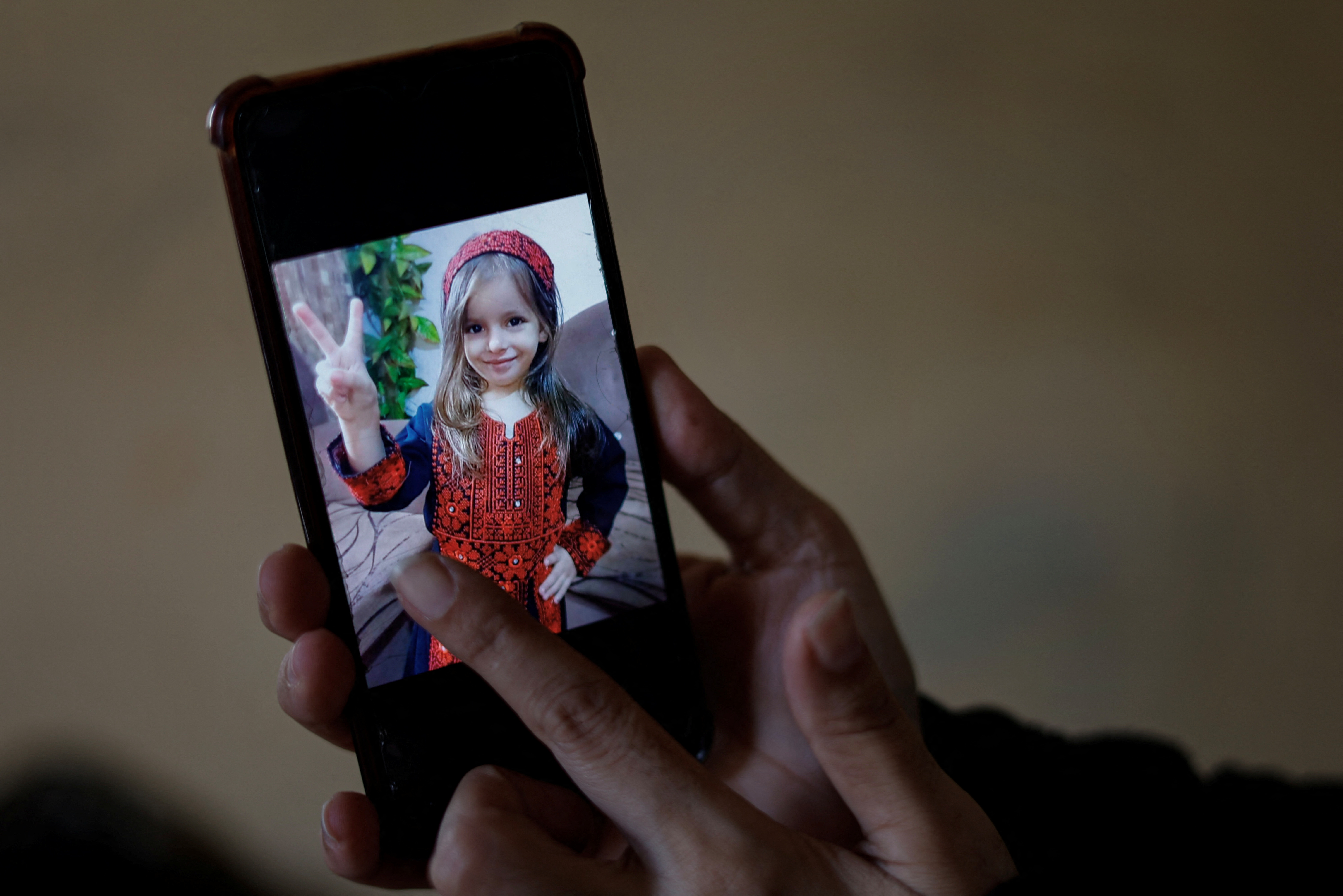 Palestinian woman Inas Abu Maamar, 36, whose picture embracing the body of her 5-year-old niece Saly who was killed in an Israeli air strike went viral on local and international media, displays Saly's picture on a mobile phone, in Khan Younis in the southern Gaza Strip.