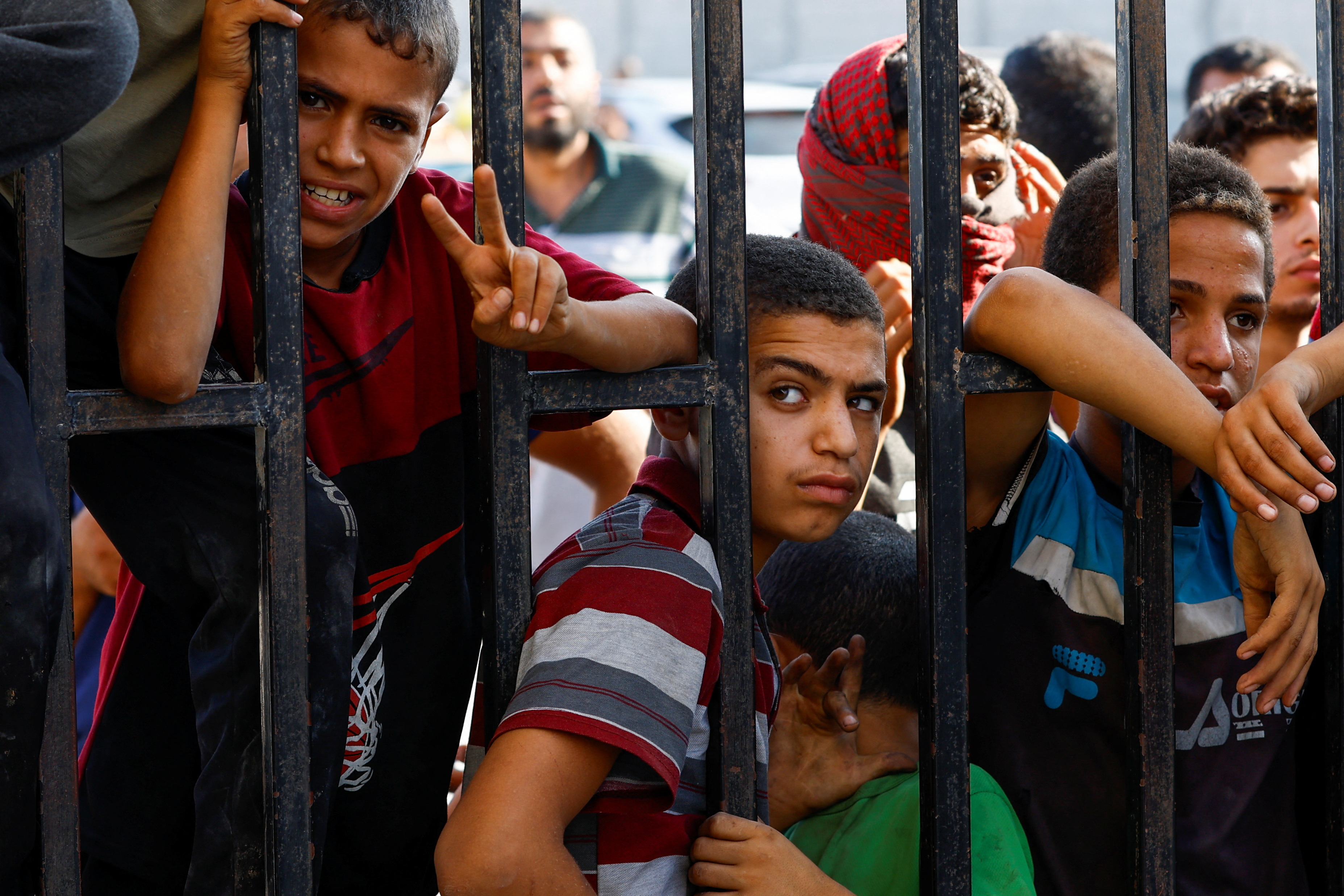 Children wait for the arrival of Palestinian workers, who were in Israel during the Hamas October 7 attack, at the Rafah border after being sent back by Israel to the strip, in the southern Gaza Strip.