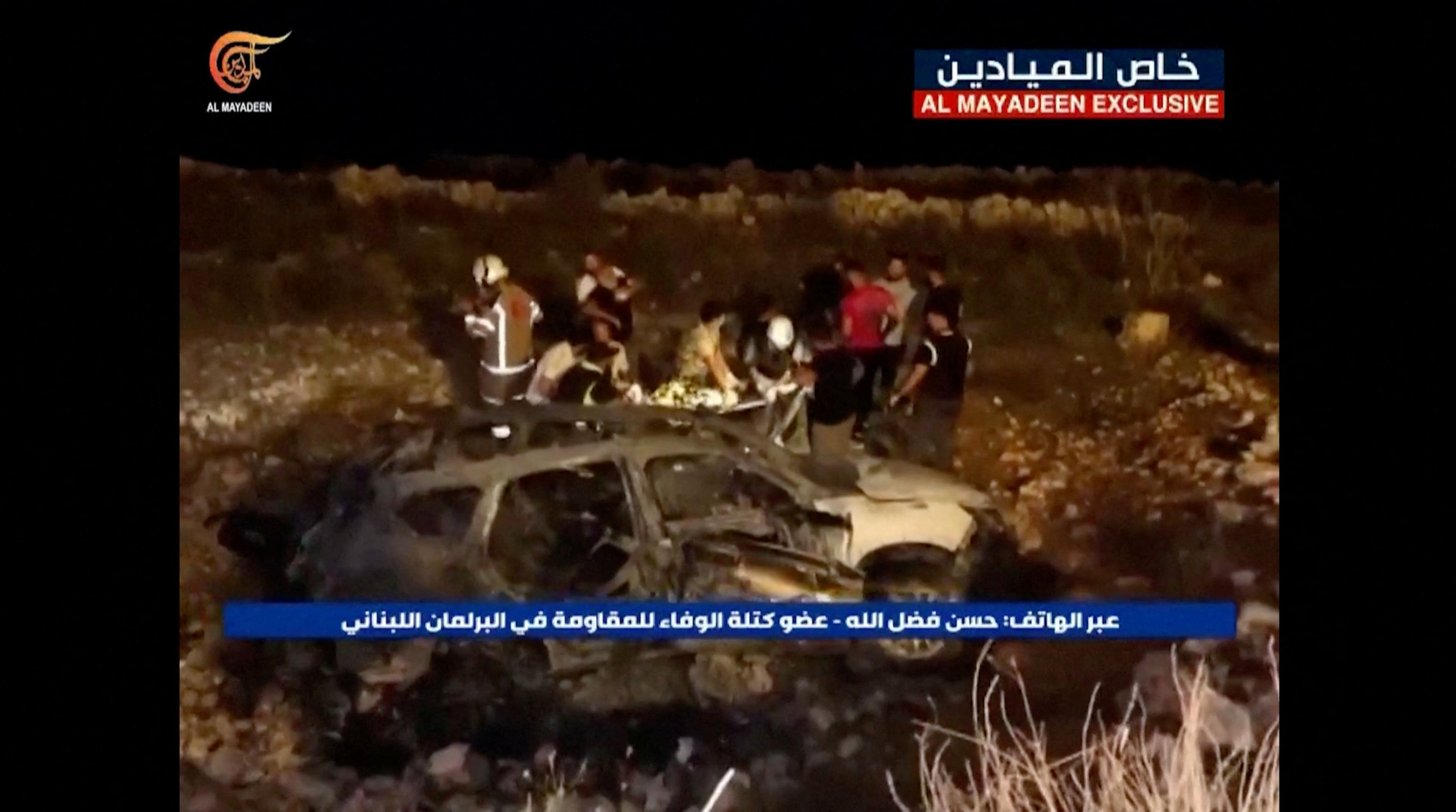 Footage from Al-Mayadeen Tv shows emergency teams working next to a burnt vehicle at the scene where Hezbollah says an Israeli strike killed three children, in southern Lebanon, November 5, 2023.