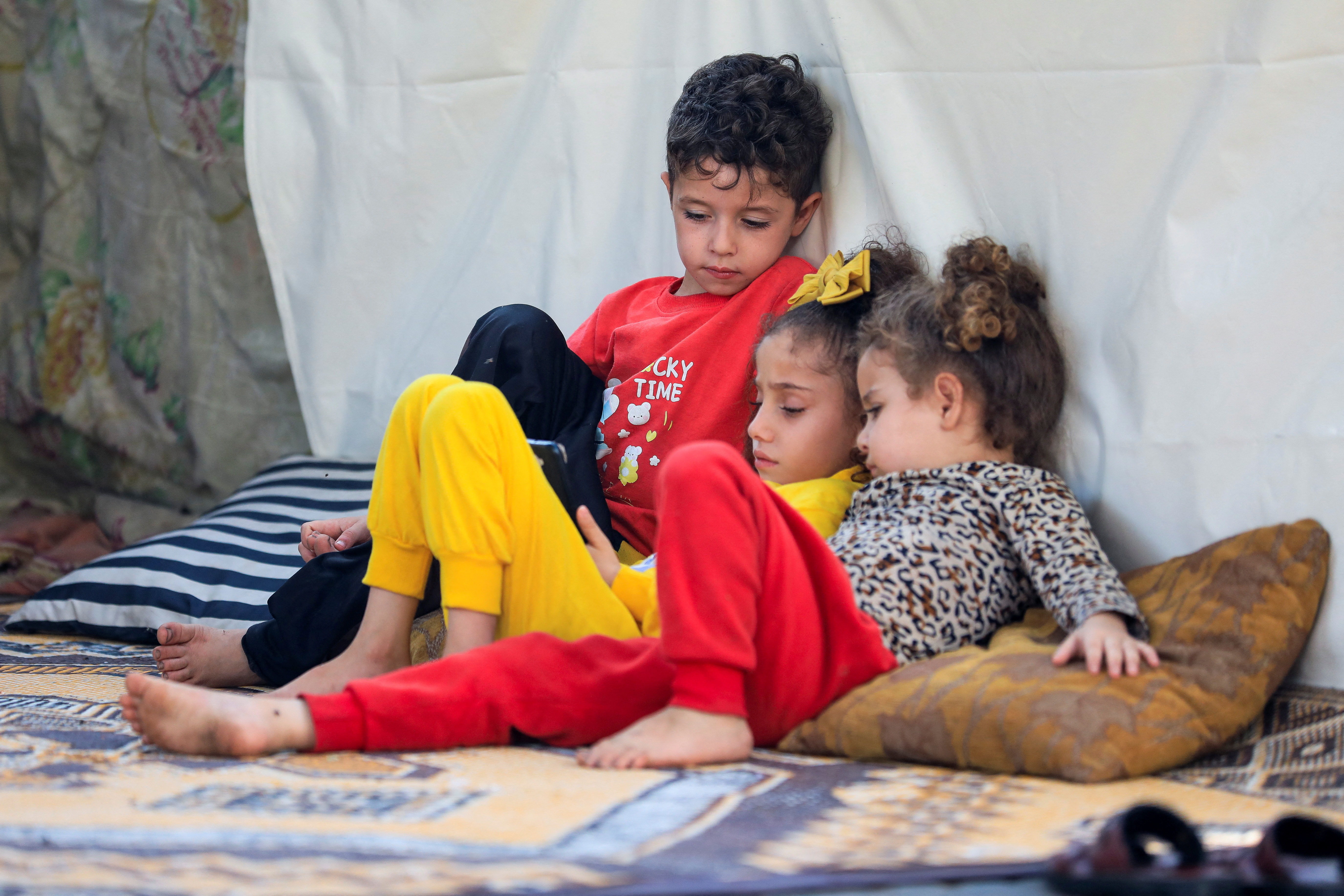 Displaced Palestinian children, who fled their house due to Israeli strikes, sit in a makeshift shelter at Shifa hospital, amid the ongoing conflict between Israel and Palestinian Islamist group Hamas, in Gaza City