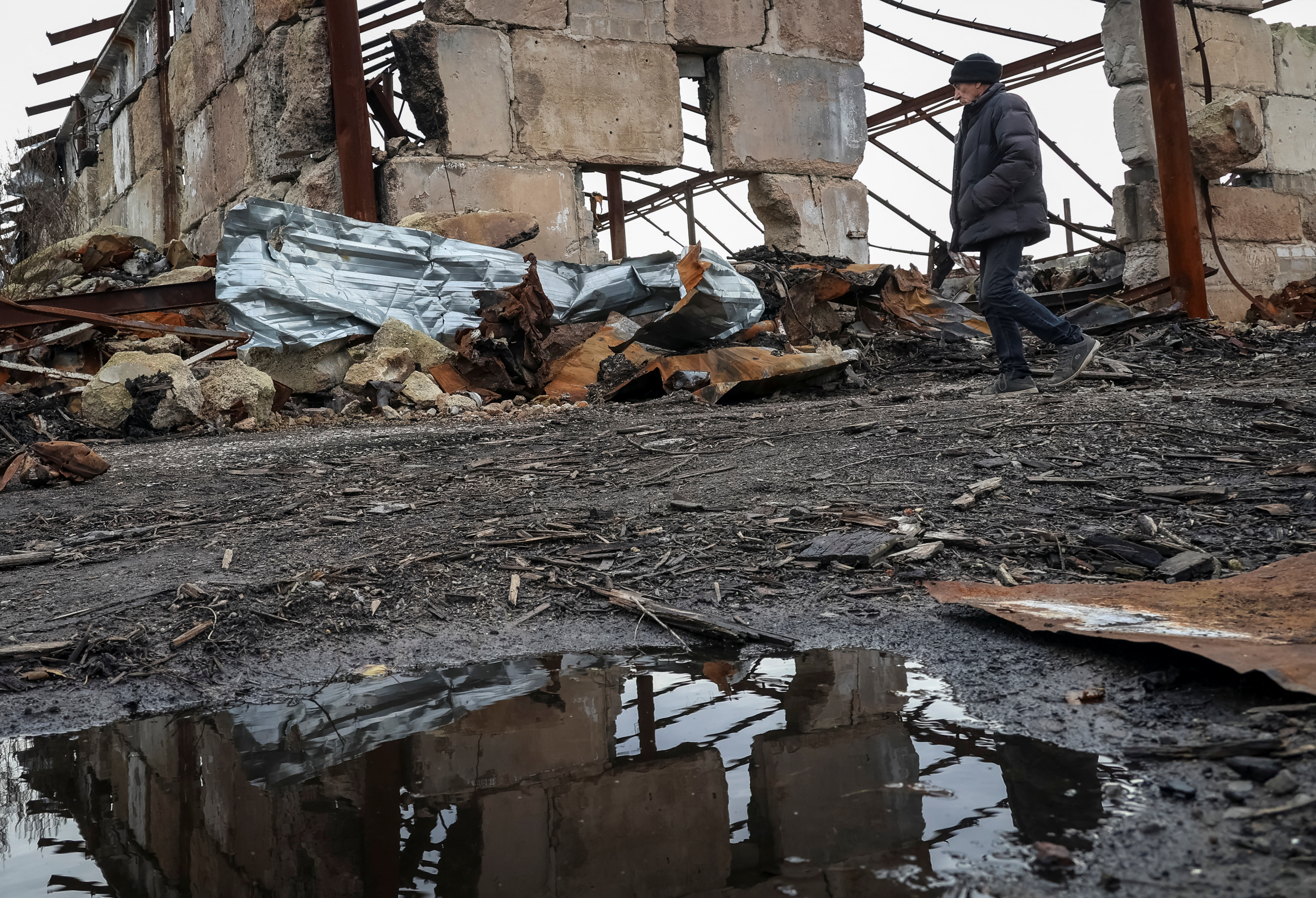 A local resident Mykola, 68, walks amidst the debris at a site of a farm that was destroyed last year by Russian military strike, amid Russia's attack on Ukraine, in the village of Kamianka in Kharkiv region, Ukraine, November 8, 2023. REUTERS/Sofiia Gatilova