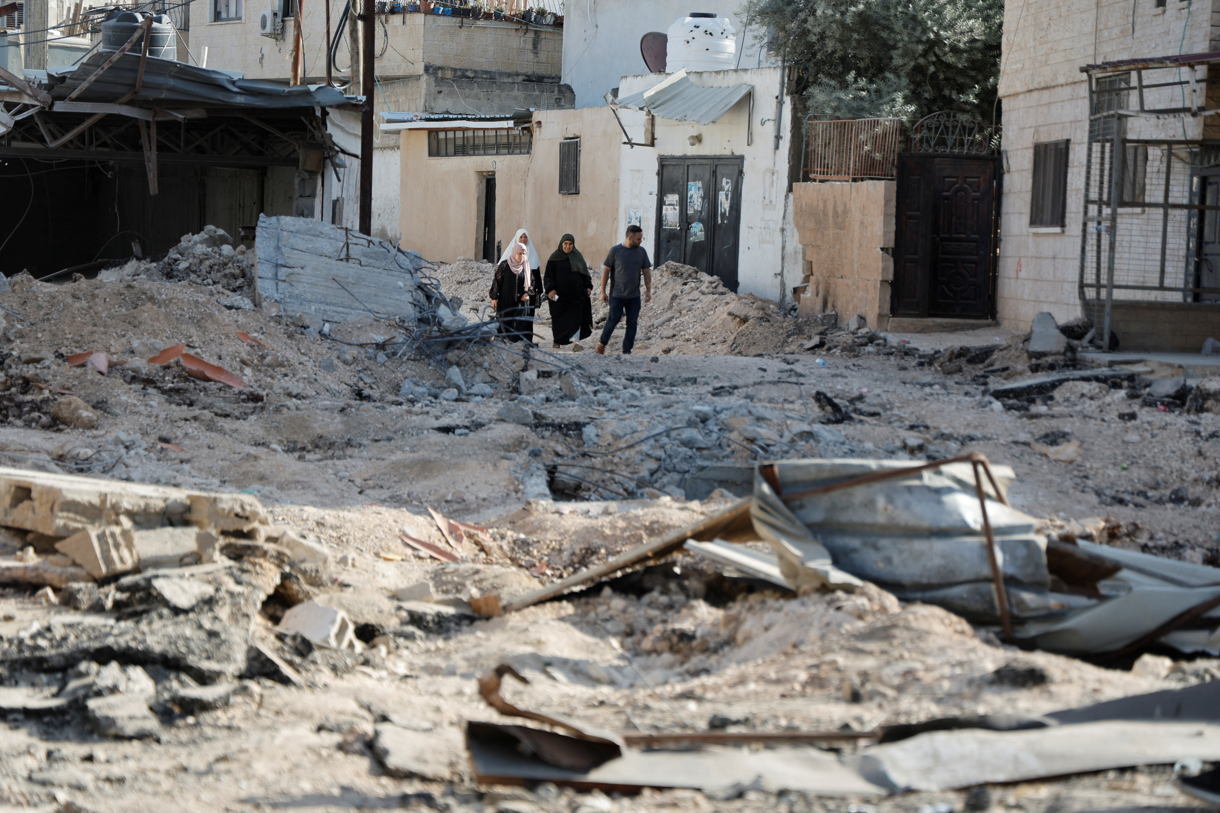 People check damage as they walk amid rubble after Israeli forces raided Jenin refugee camp in the Israeli-occupied West Bank, November 10, 2023 REUTERS/Raneen Sawafta