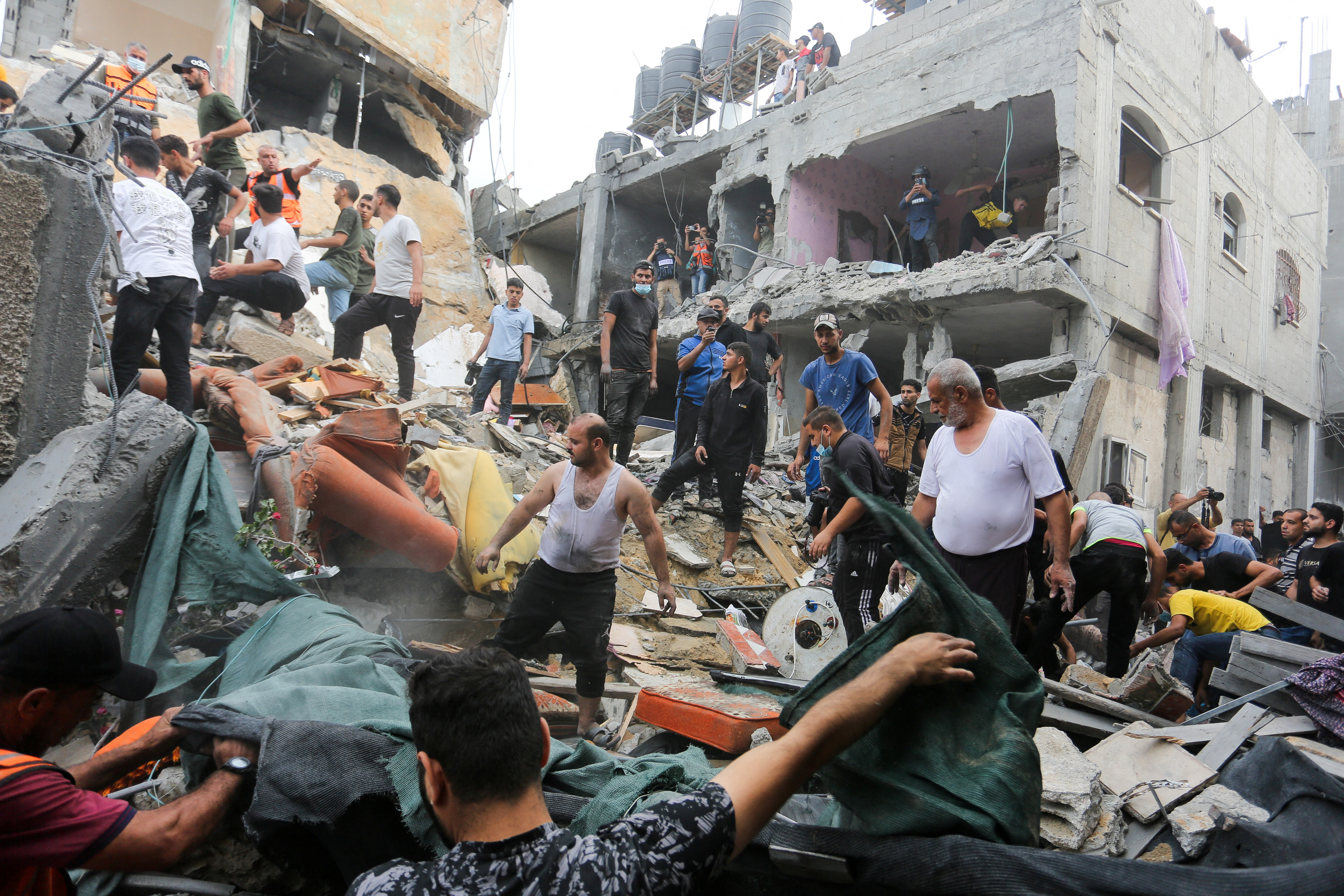 Palestinians search for casualties as they inspect the site of an Israeli strike on a house, in Rafah