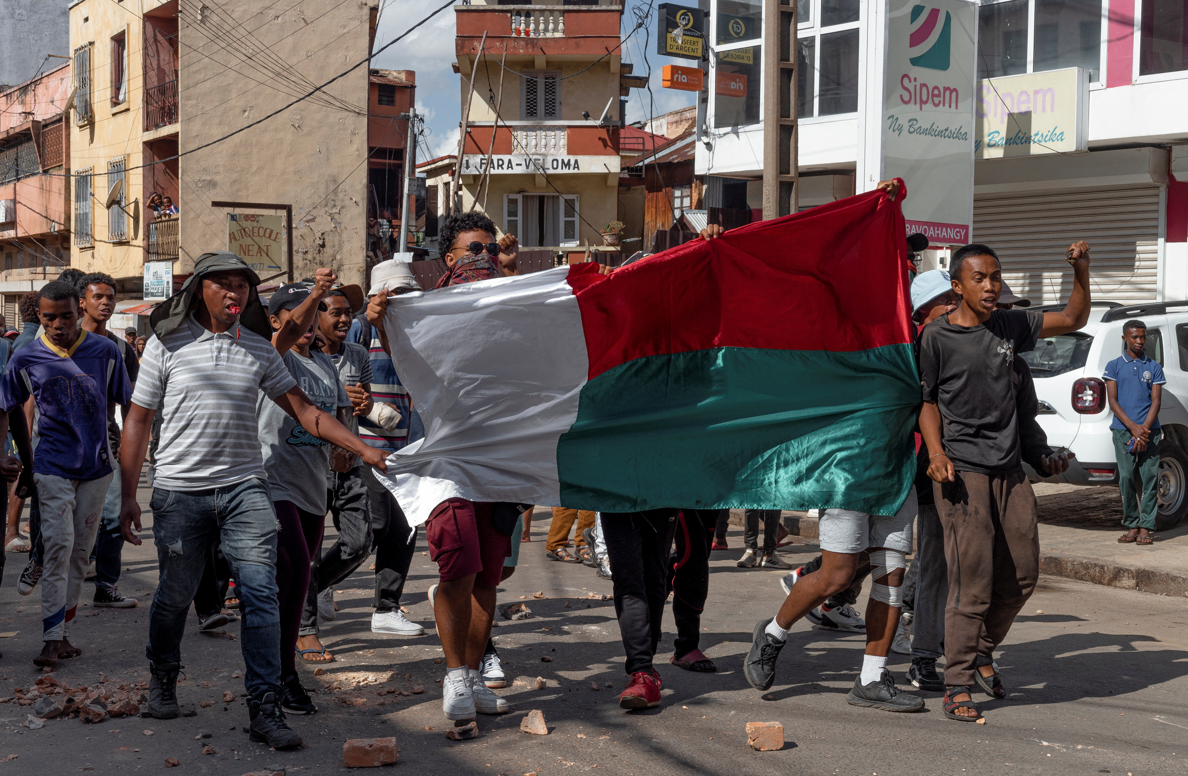 Supporters of opposition parties hold a national flag as they walk towards the riot police officers during a protest ahead of the forthcoming first round of Madagascar's presidential election in Antananarivo, Madagascar November 11, 2023. REUTERS/Zo Andrianjafy NO RESALES. NO ARCHIVES
