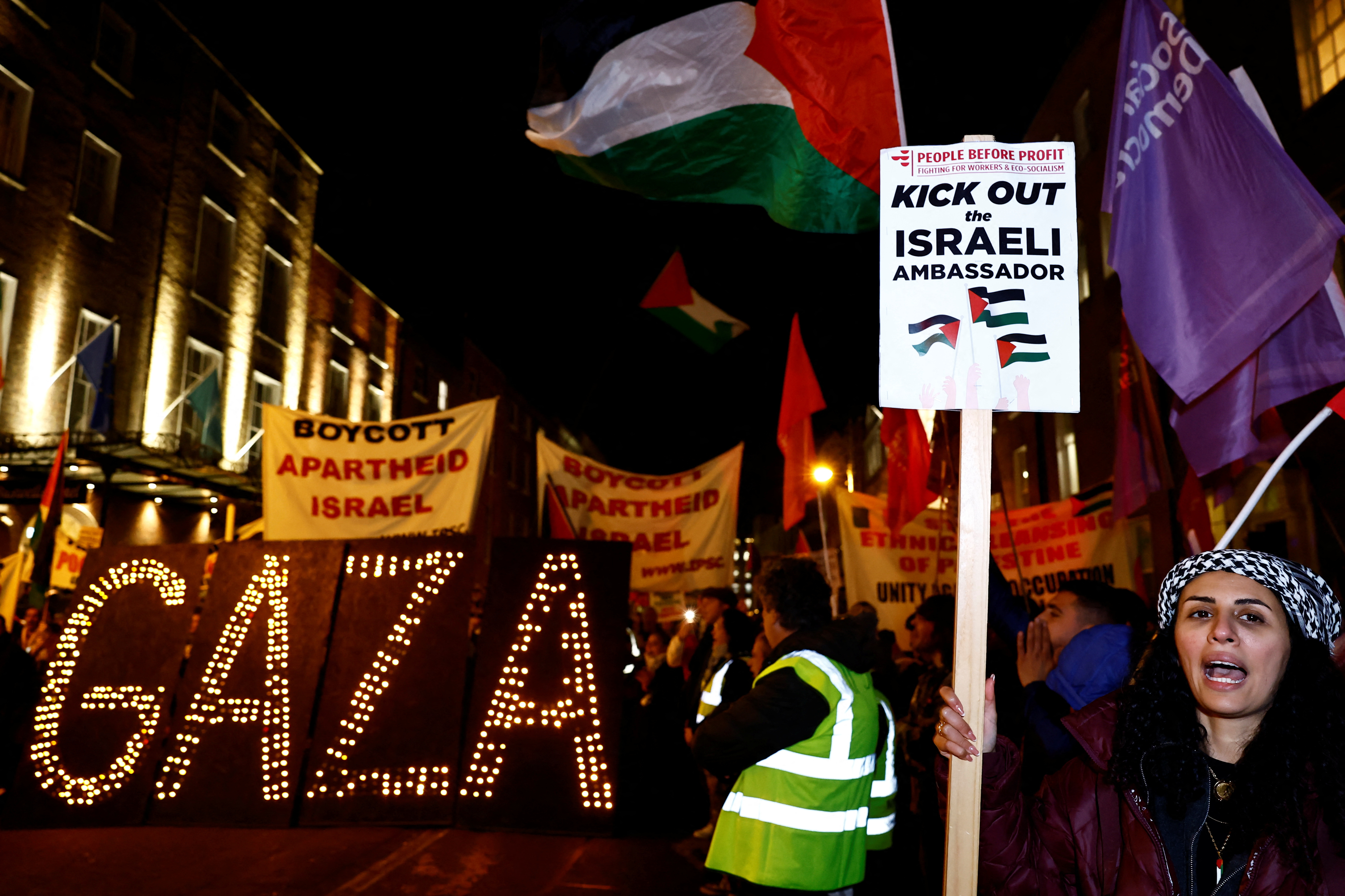 A woman holds a sign as people take part in a protest related to a Government vote to expel the Israeli Ambassador to Ireland Dana Erlich, in solidarity with Palestinians in Gaza, amid the ongoing conflict between Israel and the Palestinian Islamist group Hamas, in Dublin, Ireland, November 15, 2023. REUTERS/Clodagh Kilcoyne