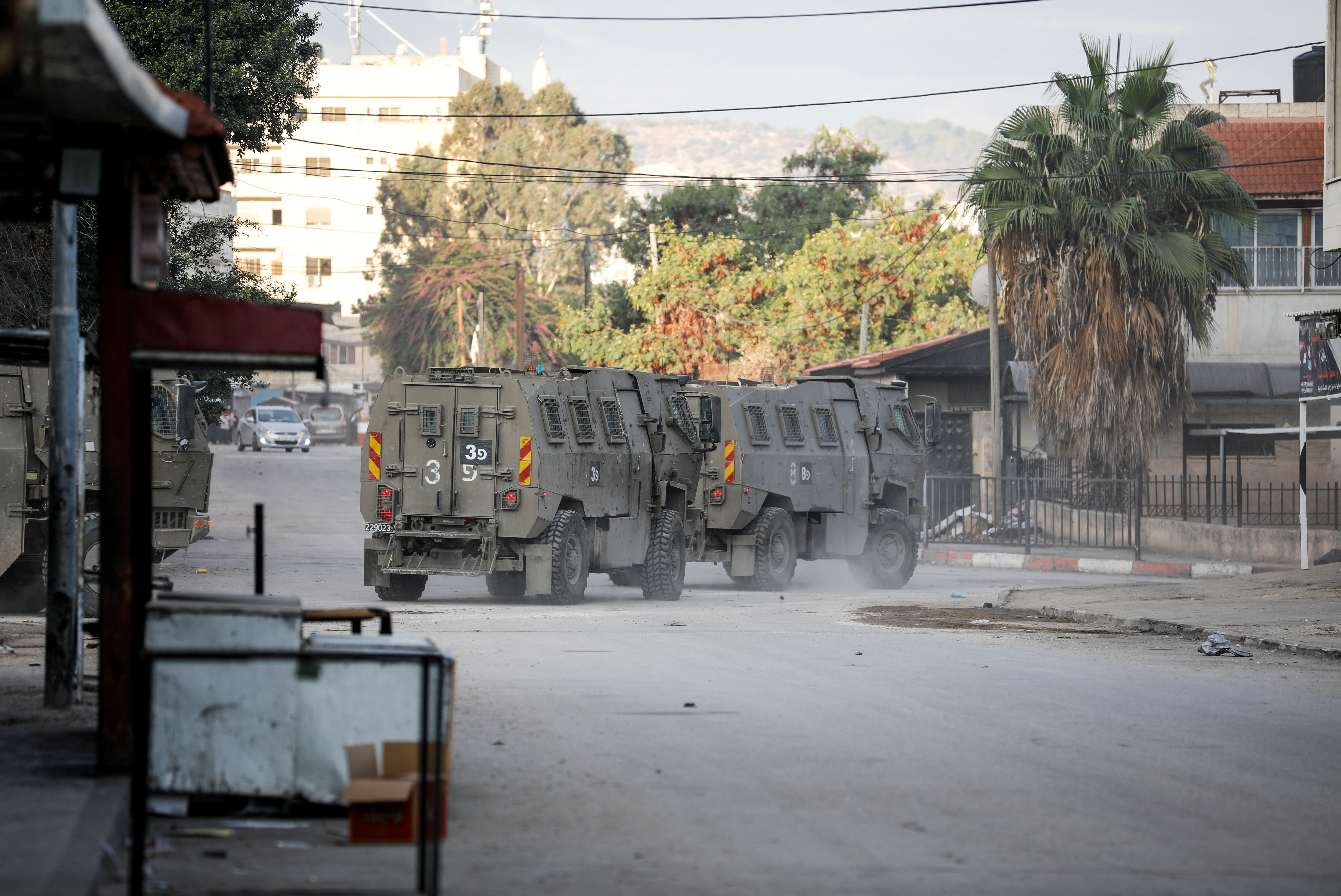 Israeli military vehicles move through a street in Jenin