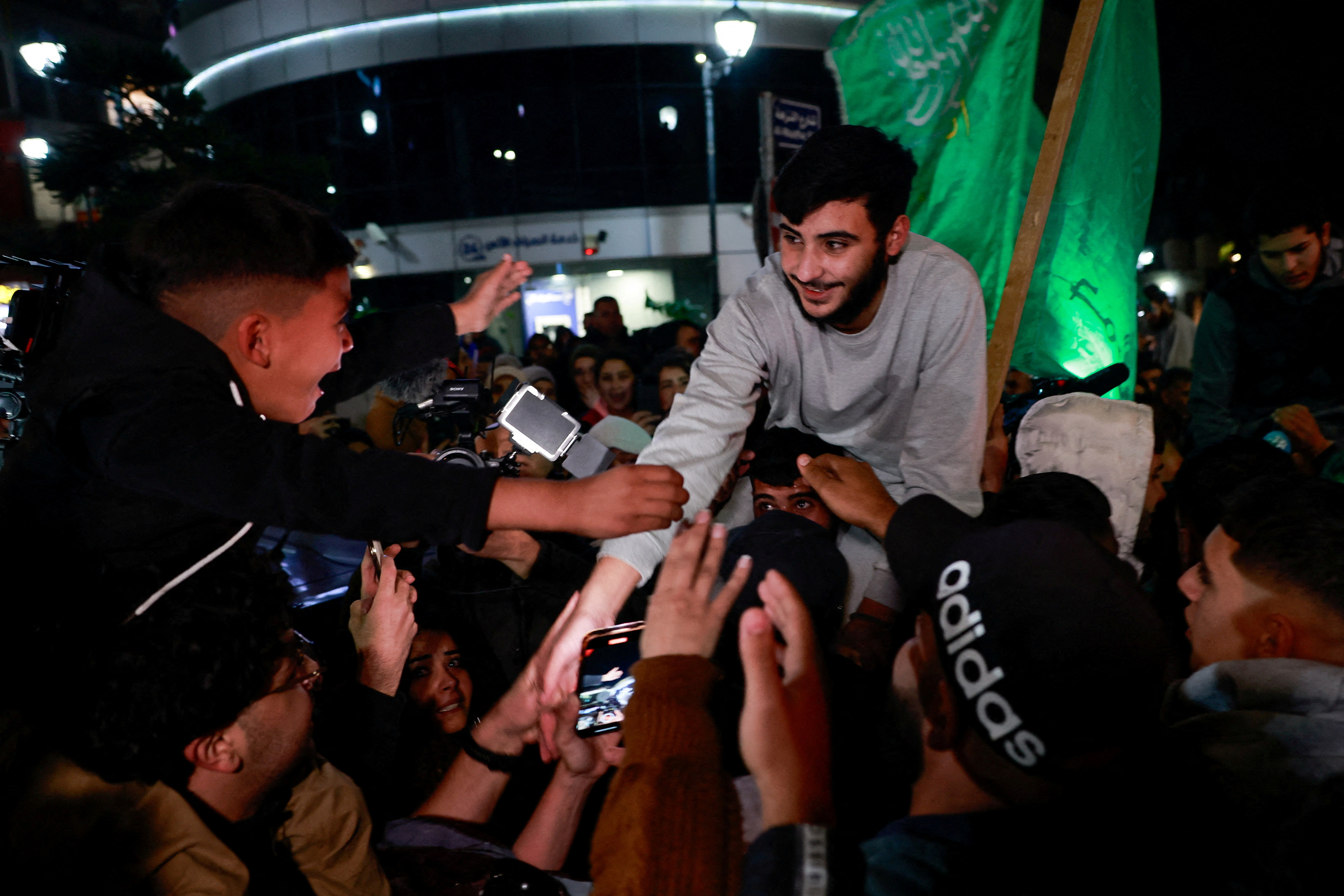 A released Palestinian prisoner reacts next to a boy after he left the Israeli military prison, Ofer, amid a hostages-prisoners swap deal between Hamas and Israel, in Ramallah in the Israeli-occupied West Bank November 26, 2023