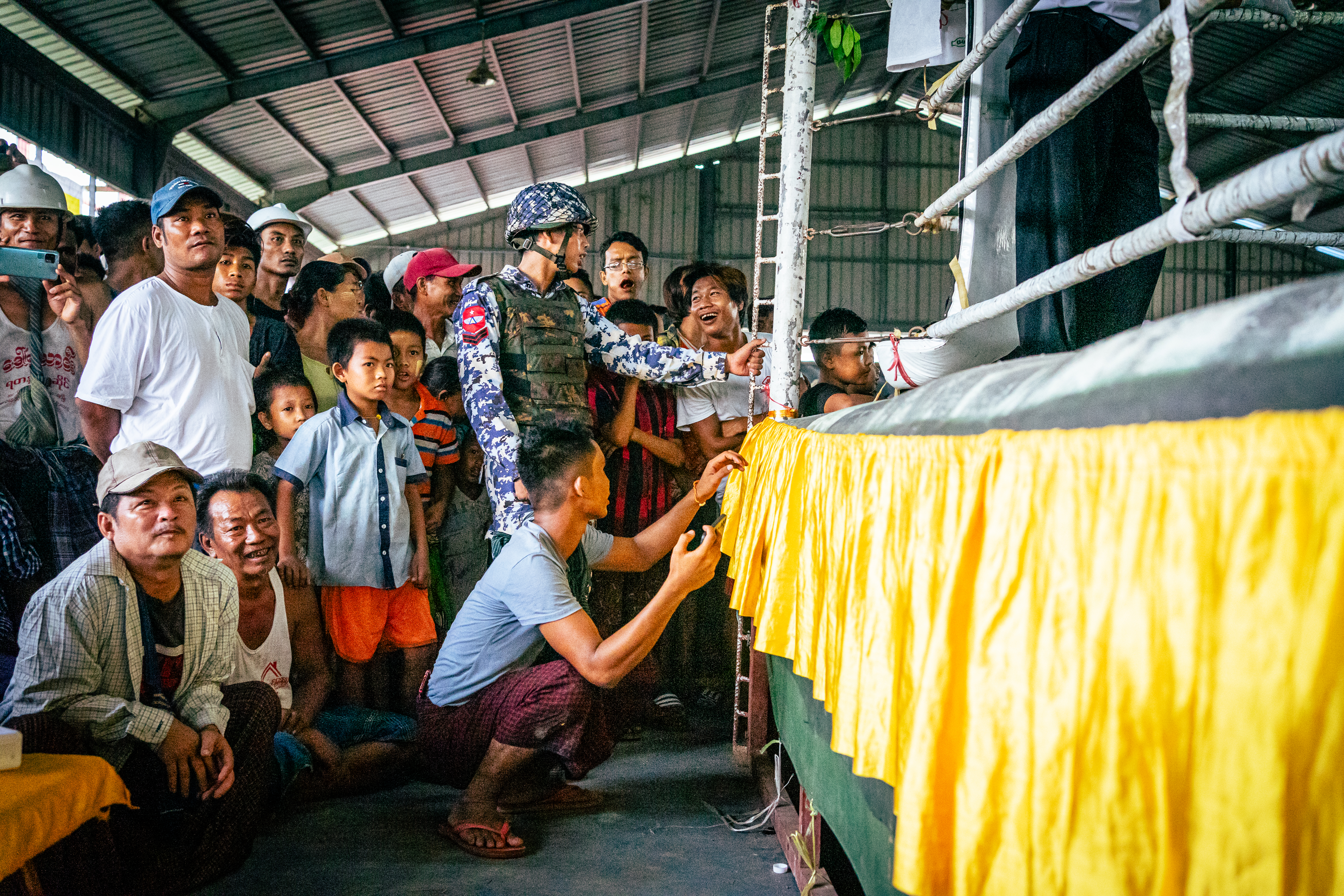 A corporal in Myanmar’s Air Force stands guard at the corner of the ring, surrounded by lethwei fans.