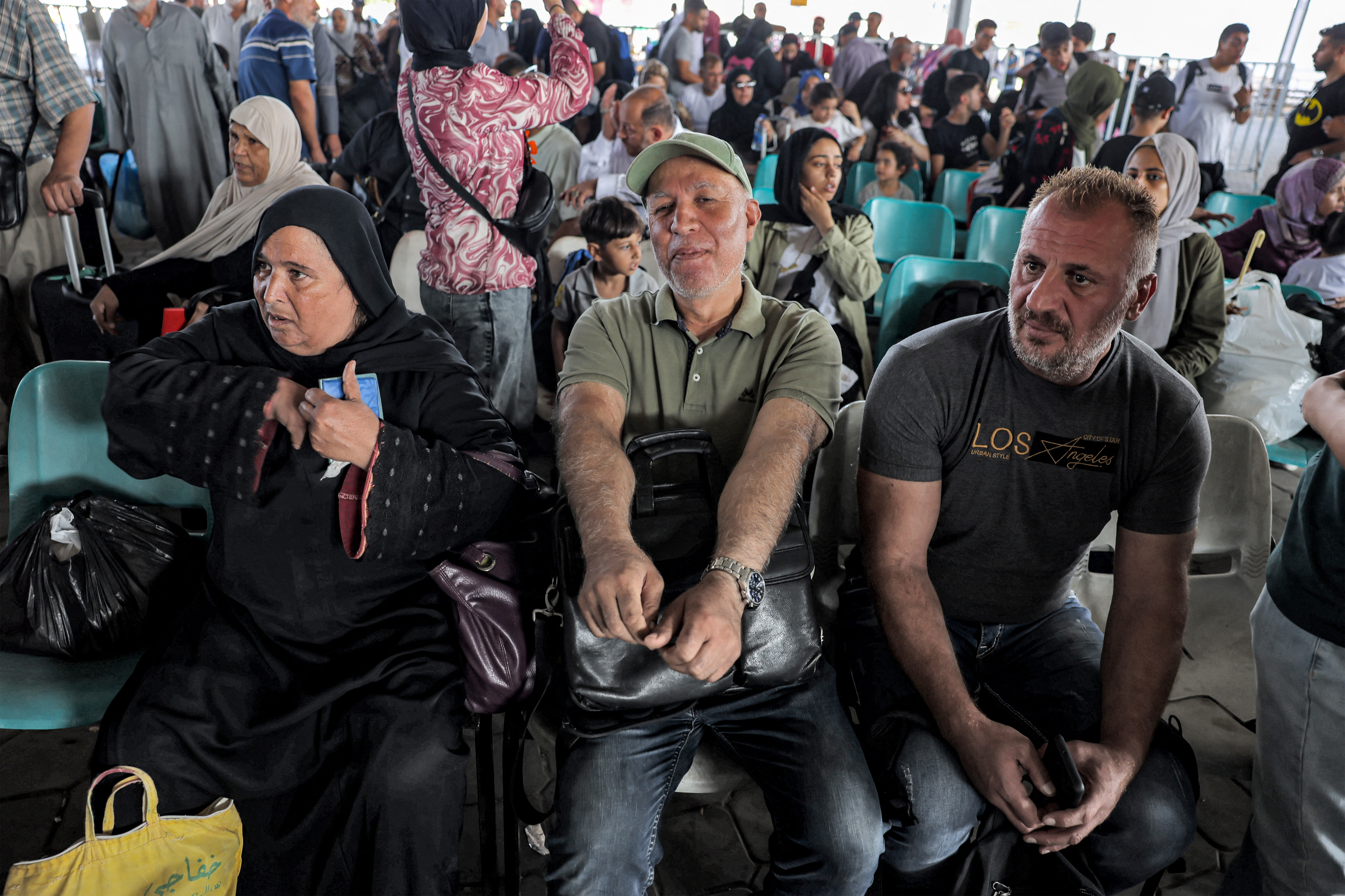 People sit in the waiting area at the Rafah border crossing