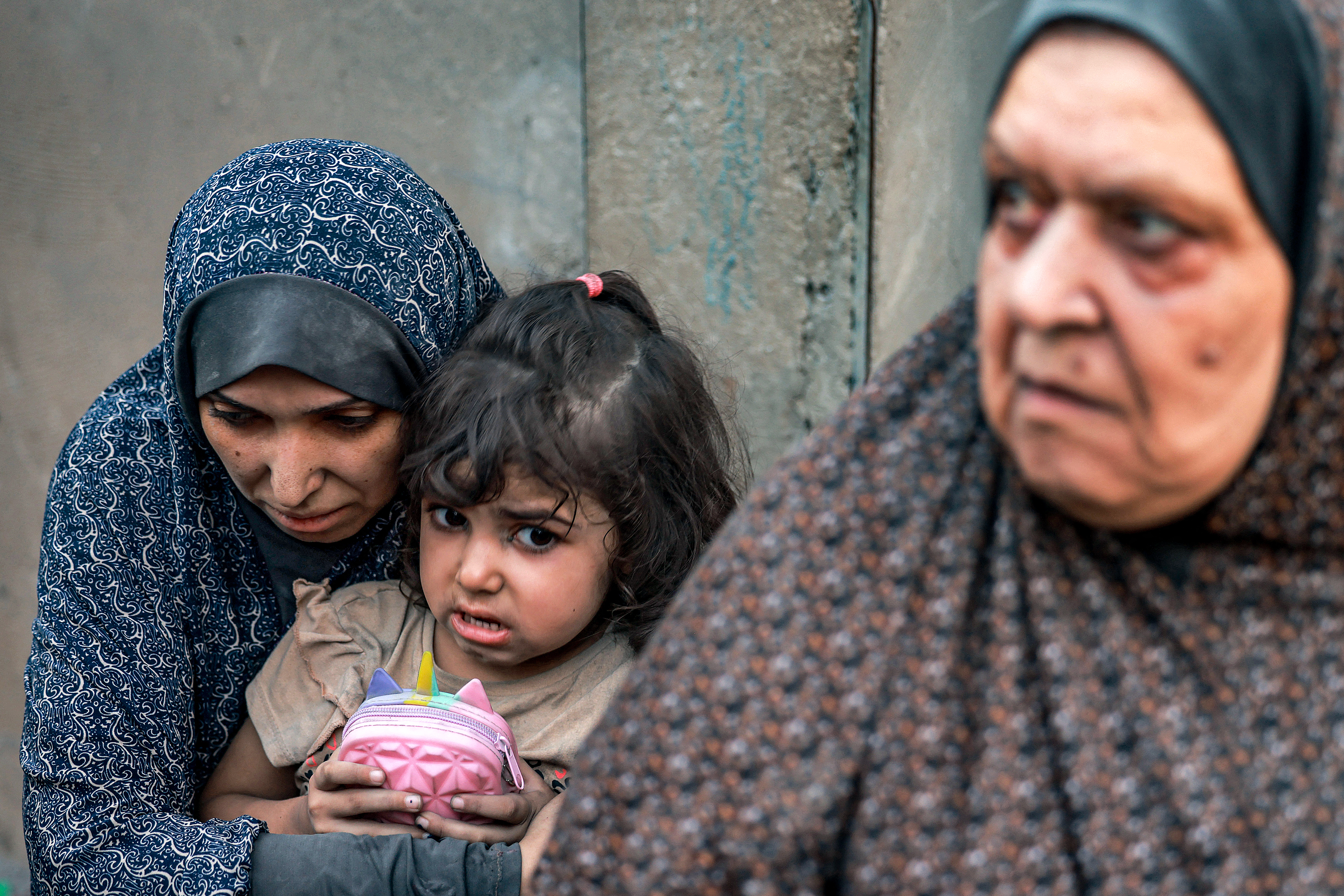 A Palestinian family sits near destroyed houses following a strike in Rafah on the southern Gaza Strip on November 6, 2023, amid the ongoing battles between Isreal and the militant group Hamas.