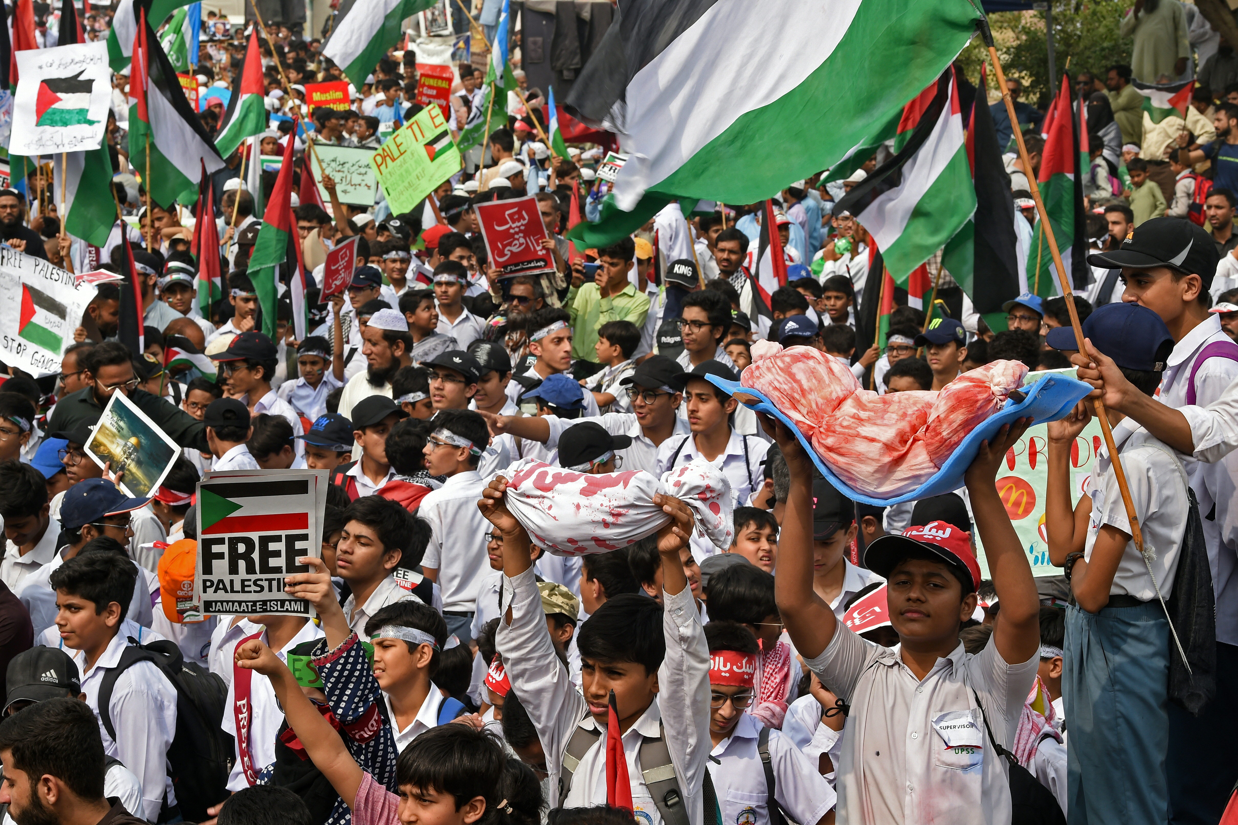 Students hold dummy bodies of victims during a rally in support of Palestinians, in Karachi.