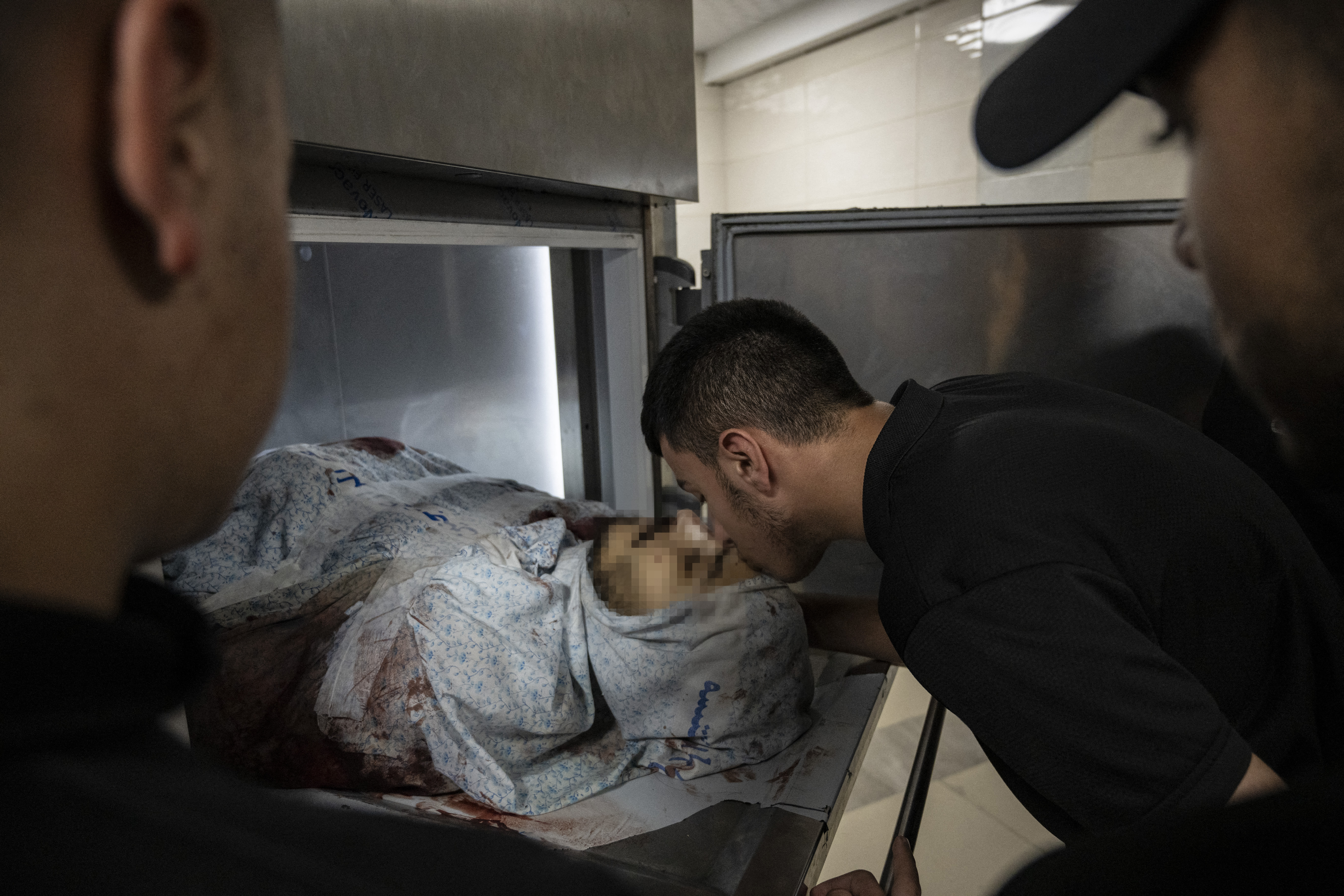A man bids farewell to a Palestinian youth killed during confrontations with Israeli forces in the occupied West Bank city of Jenin, at the morgue of a hospital.