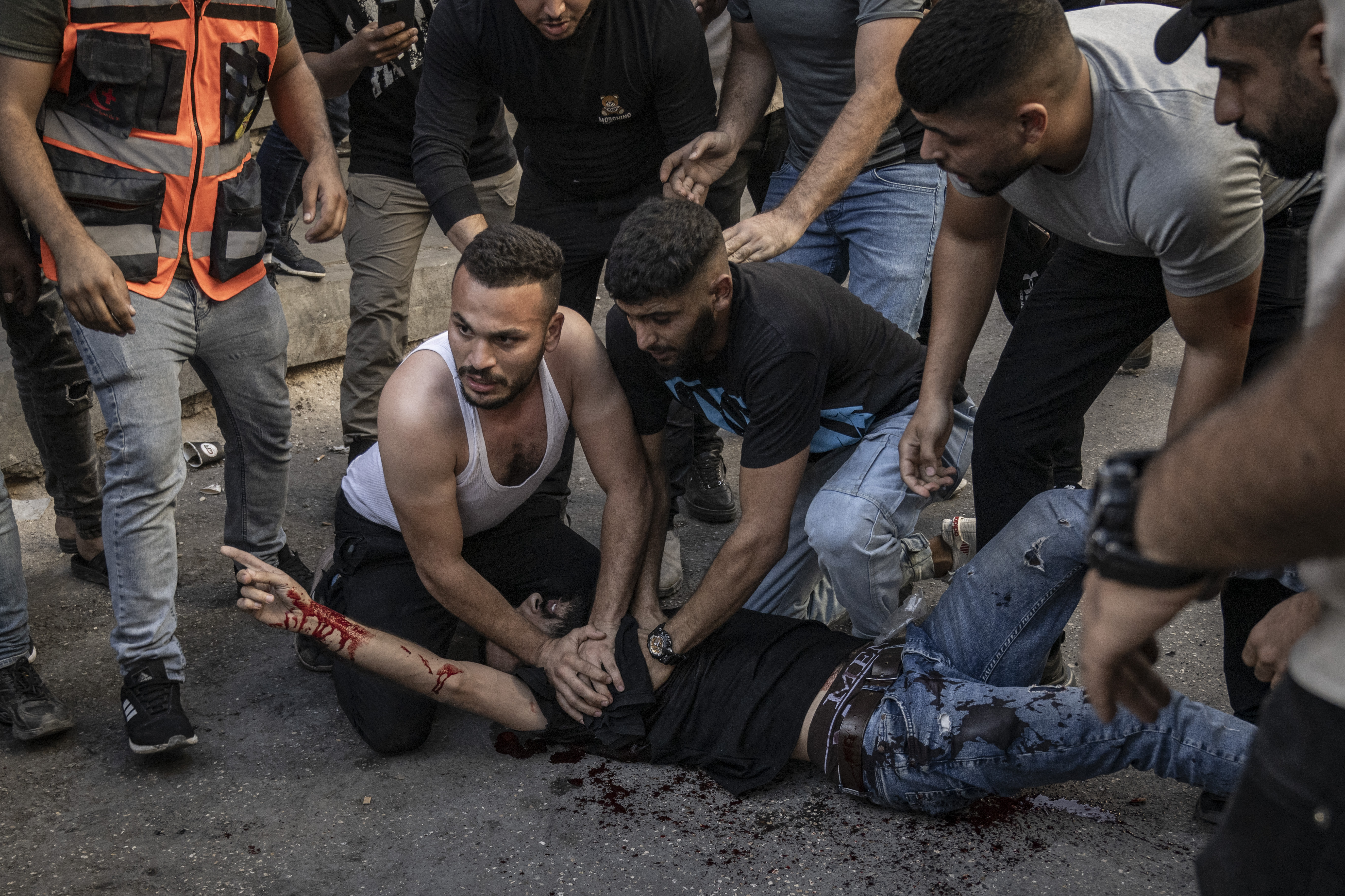 People assist an injured man after being reportedly shot by Israeli forces during confrontations with them in the occupied West Bank city of Jenin.