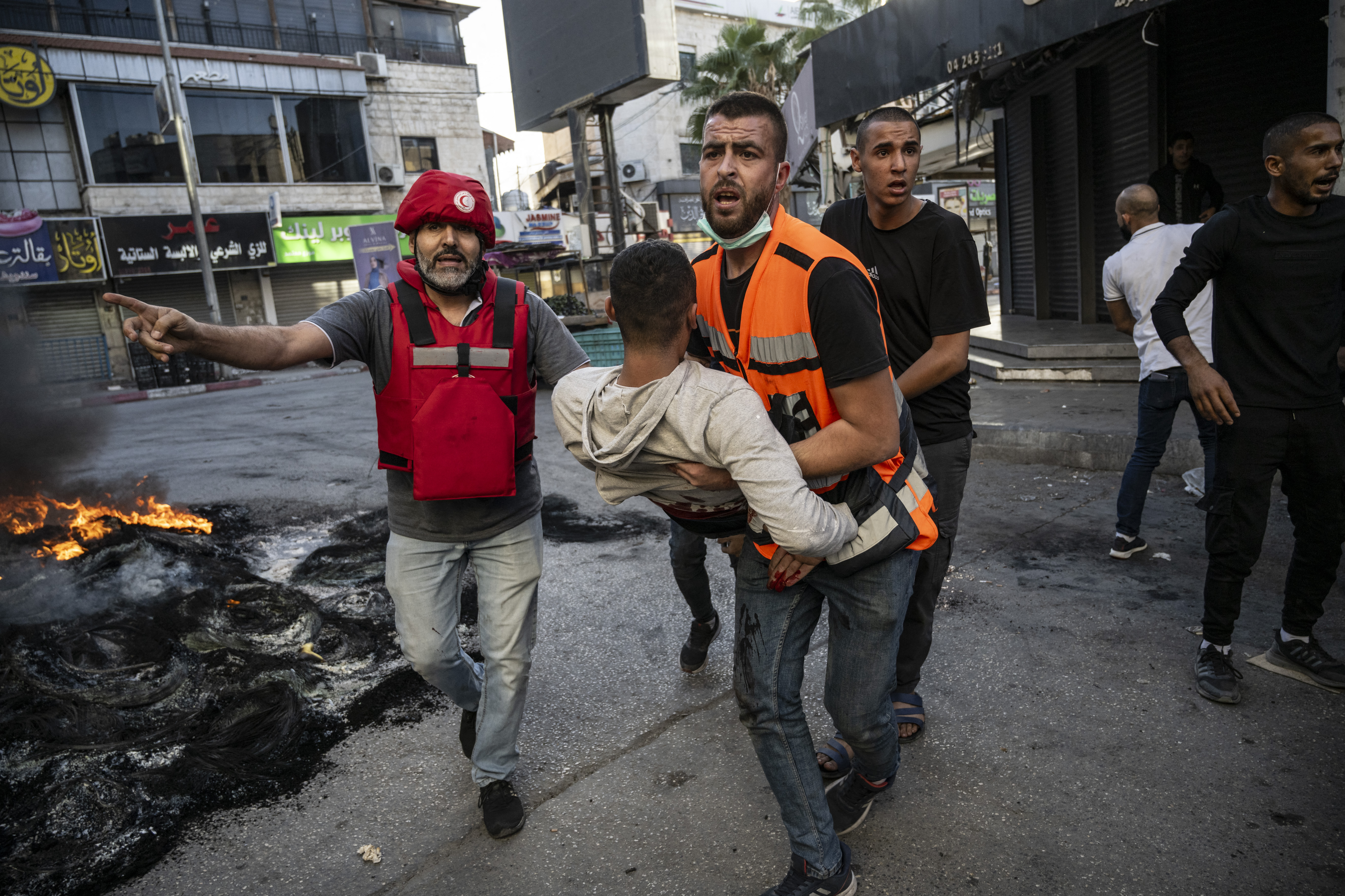 An injured man is carried away after being reportedly shot by Israeli forces during confrontations with them in the occupied West Bank city of Jenin.
