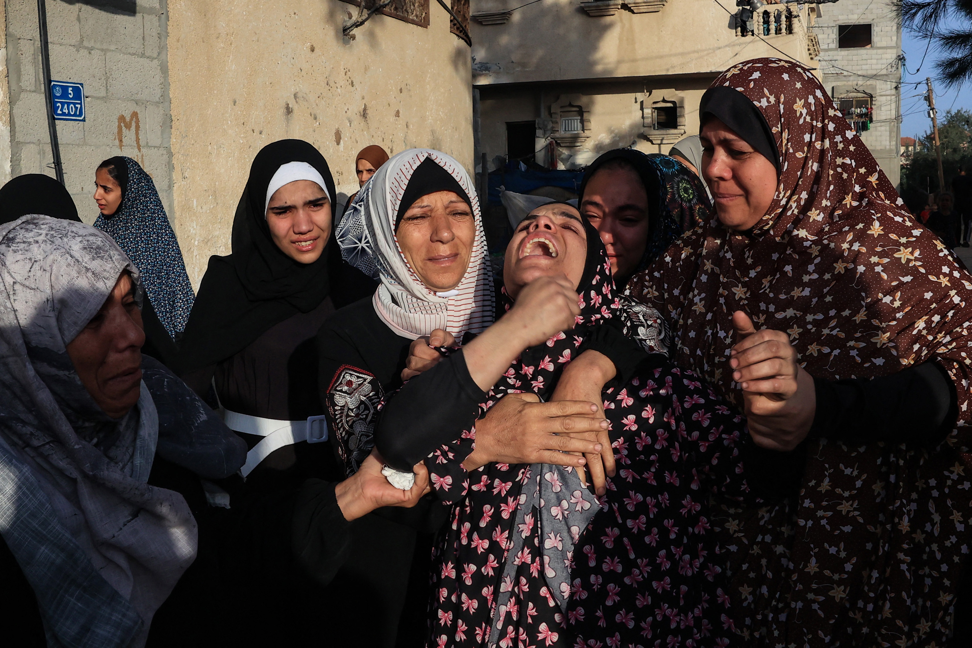 Women react during the funeral of the Faojo family, killed in Israeli bombing on Rafah in the southern Gaza Strip on November 11