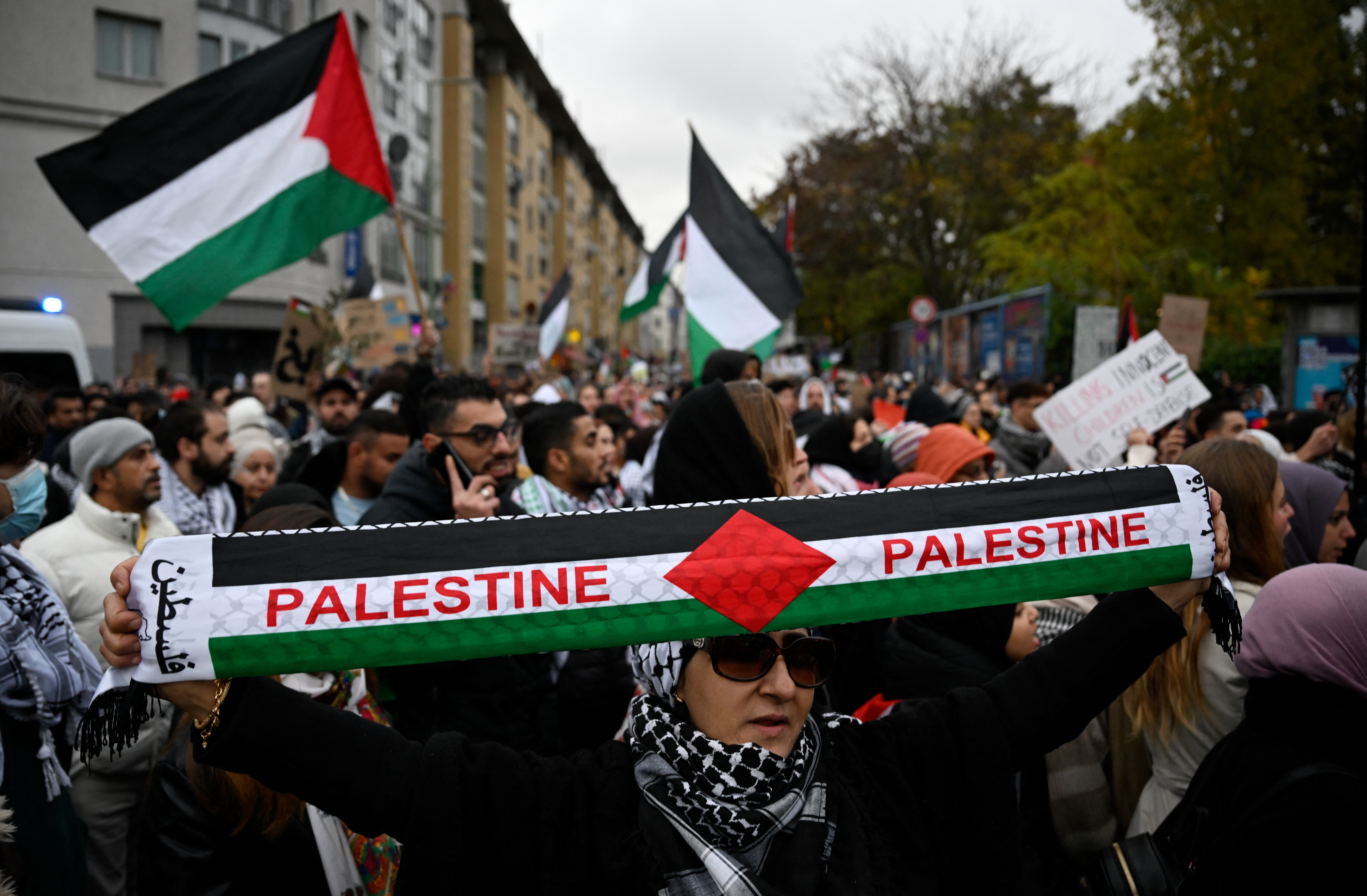 A demonstrator holds up a scarf with the lettering 'Palestine' during a rally in solidarity with Palestinians at Oranienplatz Square in Berlin's Kreuzberg district, Germany.