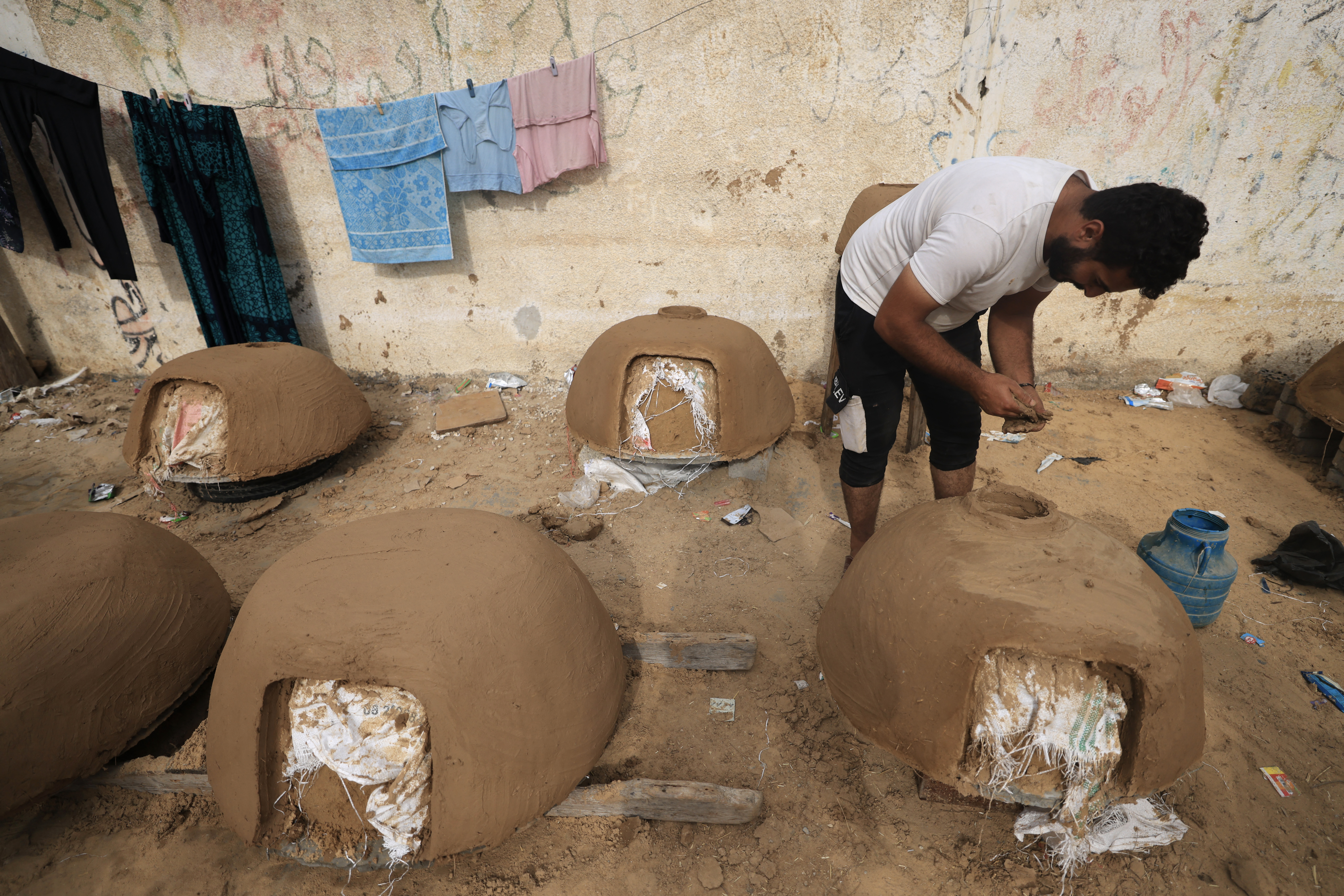 A Palestinian man moulds the clay as he make traditional Tabun ovens which he sell for 25 US dollars, as gas supplies to run gas cookers become scarce, in Khan Yunis in the southern Gaza Strip.