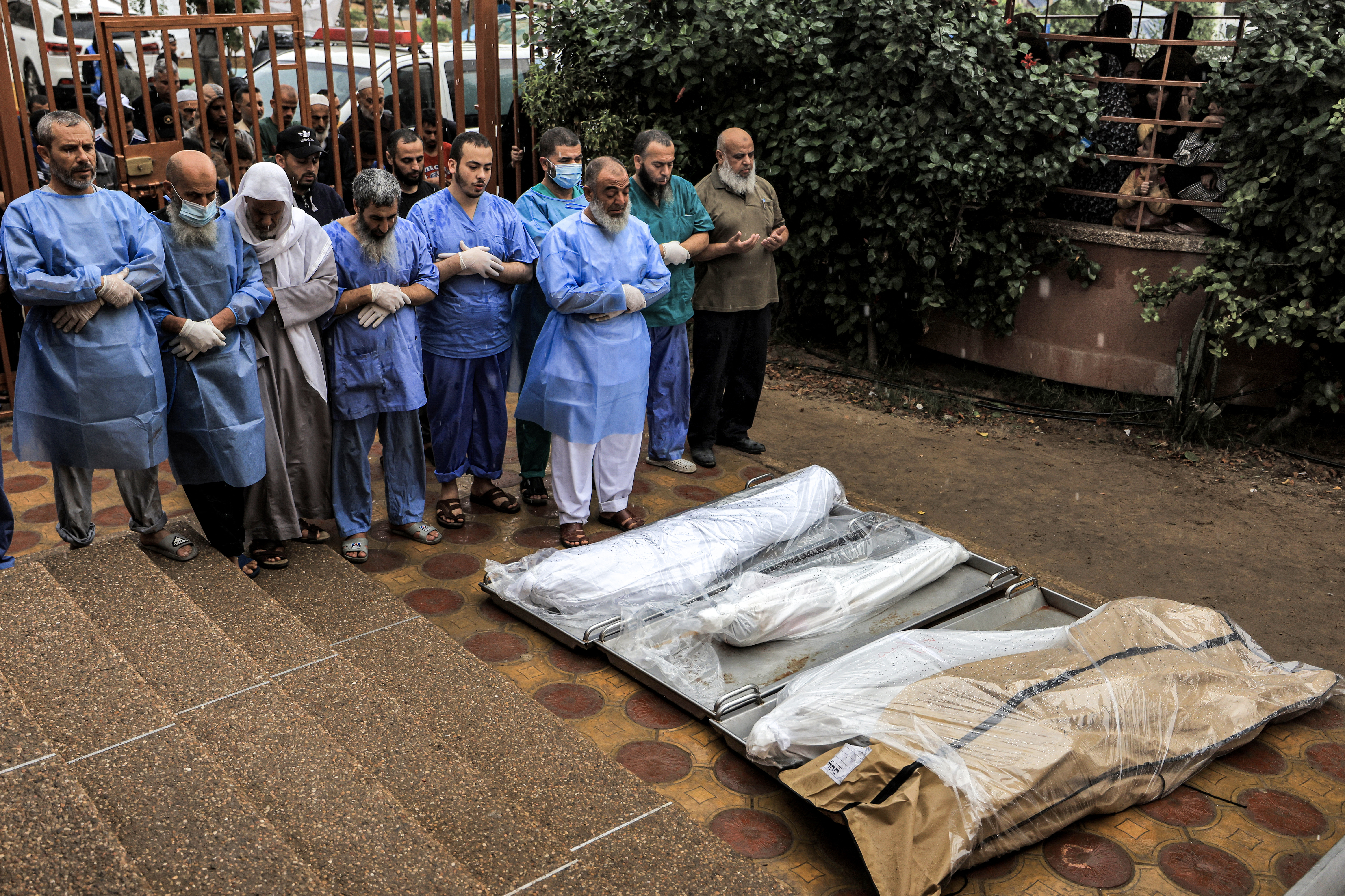 Physicians and other men pray before some of the bodies of victims who were killed in Israeli bombardment before their burial, outside the morgue at Nasser hospital in Khan Yunis in the southern Gaza Strip.