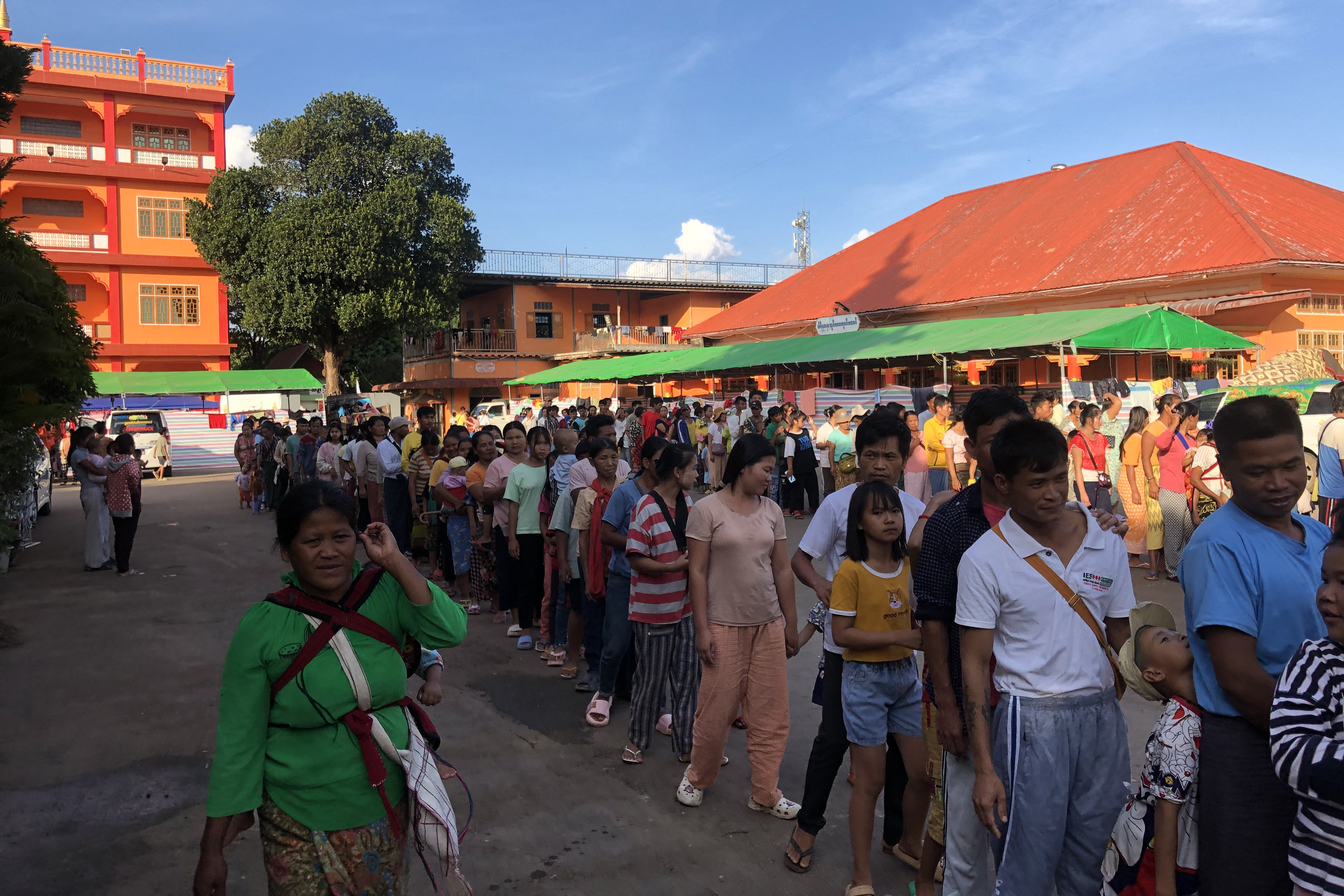 People queueing for food at a monastery providing temporary shelter to people displaced by fighting