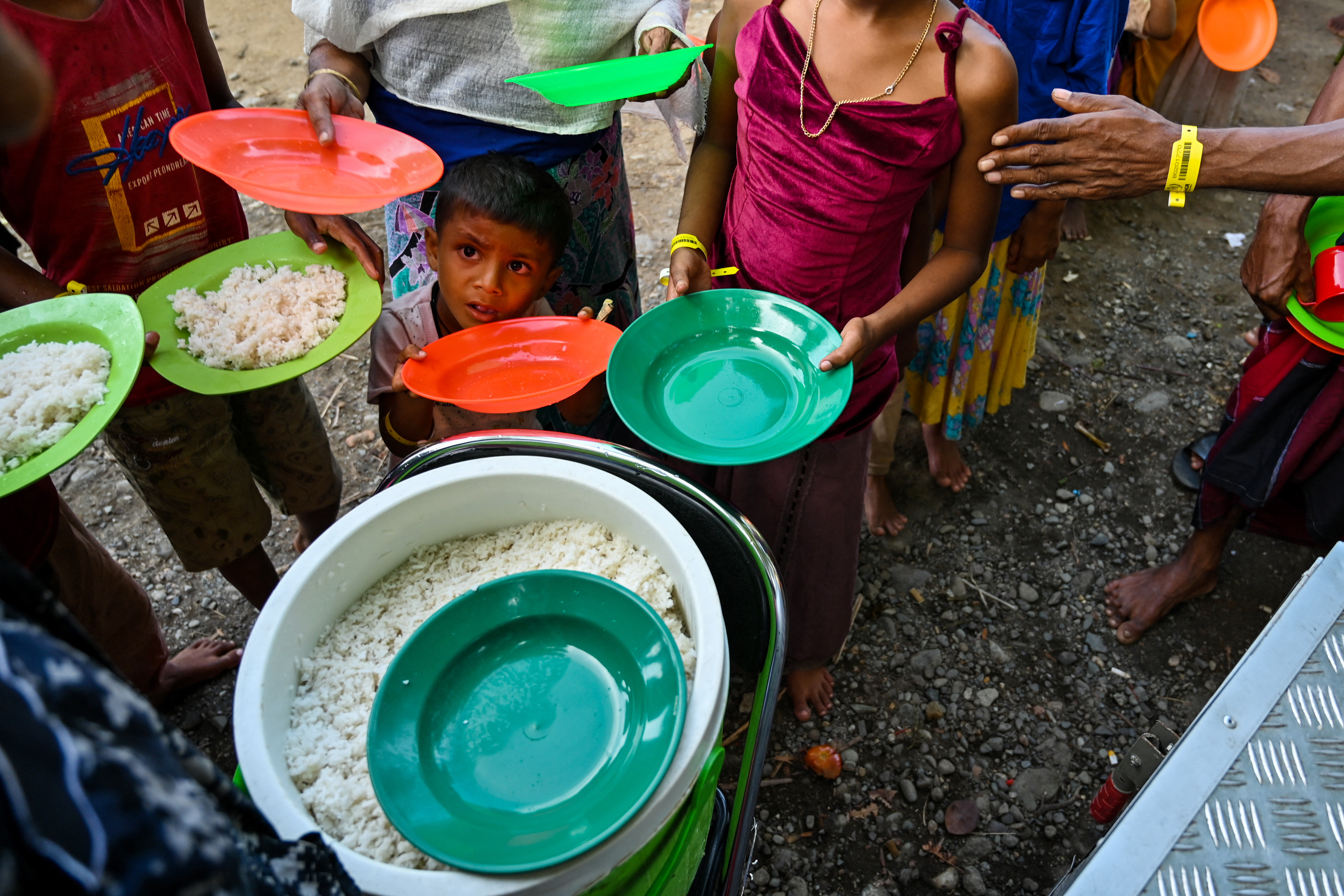 Rohingya refugees queue for breakfast following their arrival at a makeshift shelter in Padang Tiji, Indonesia's Aceh province.