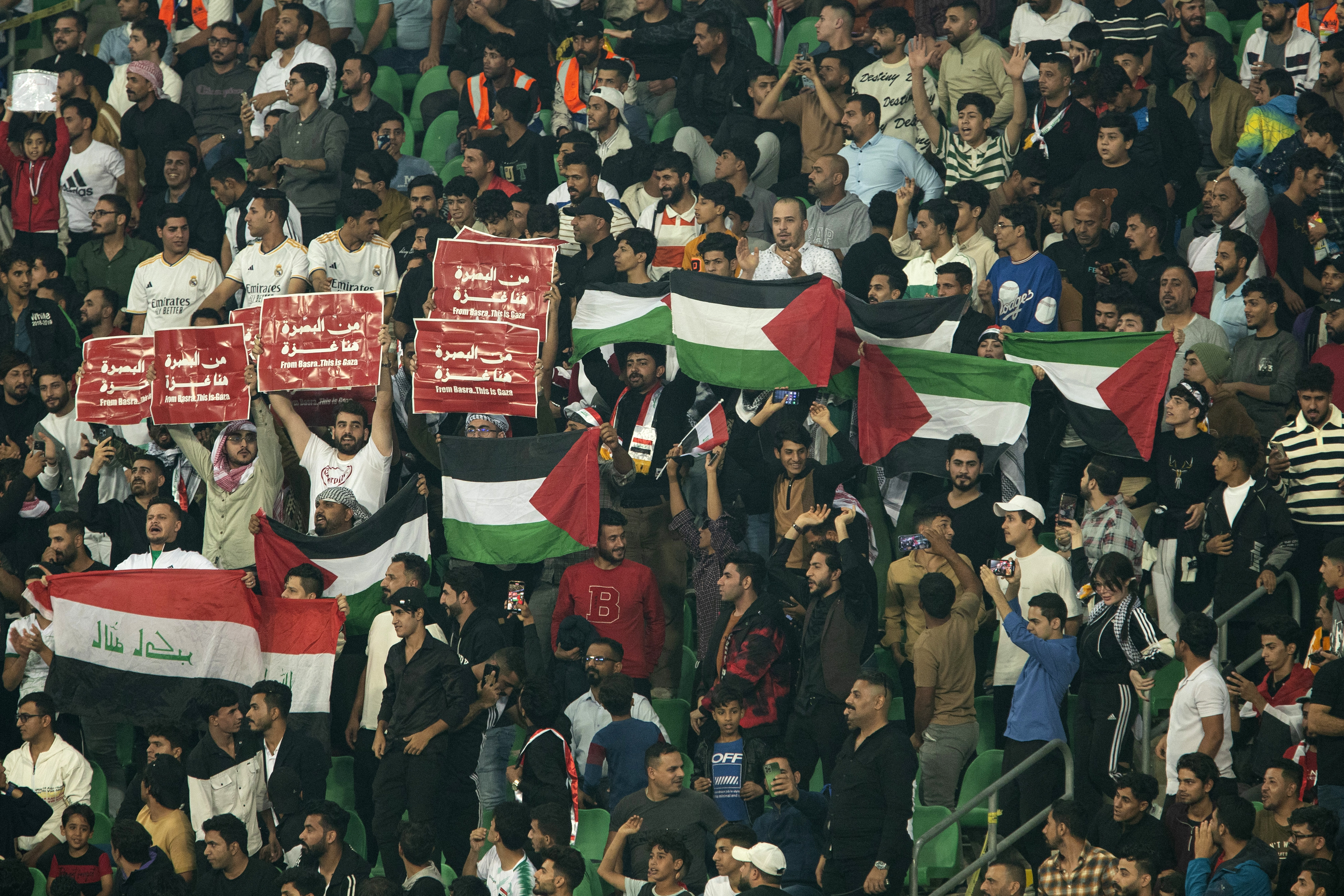 Iraq supporters wave the Palestinian flag during the 2026 FIFA World Cup AFC qualifiers football match between Iraq and Indonesia at the Basra International Stadium.