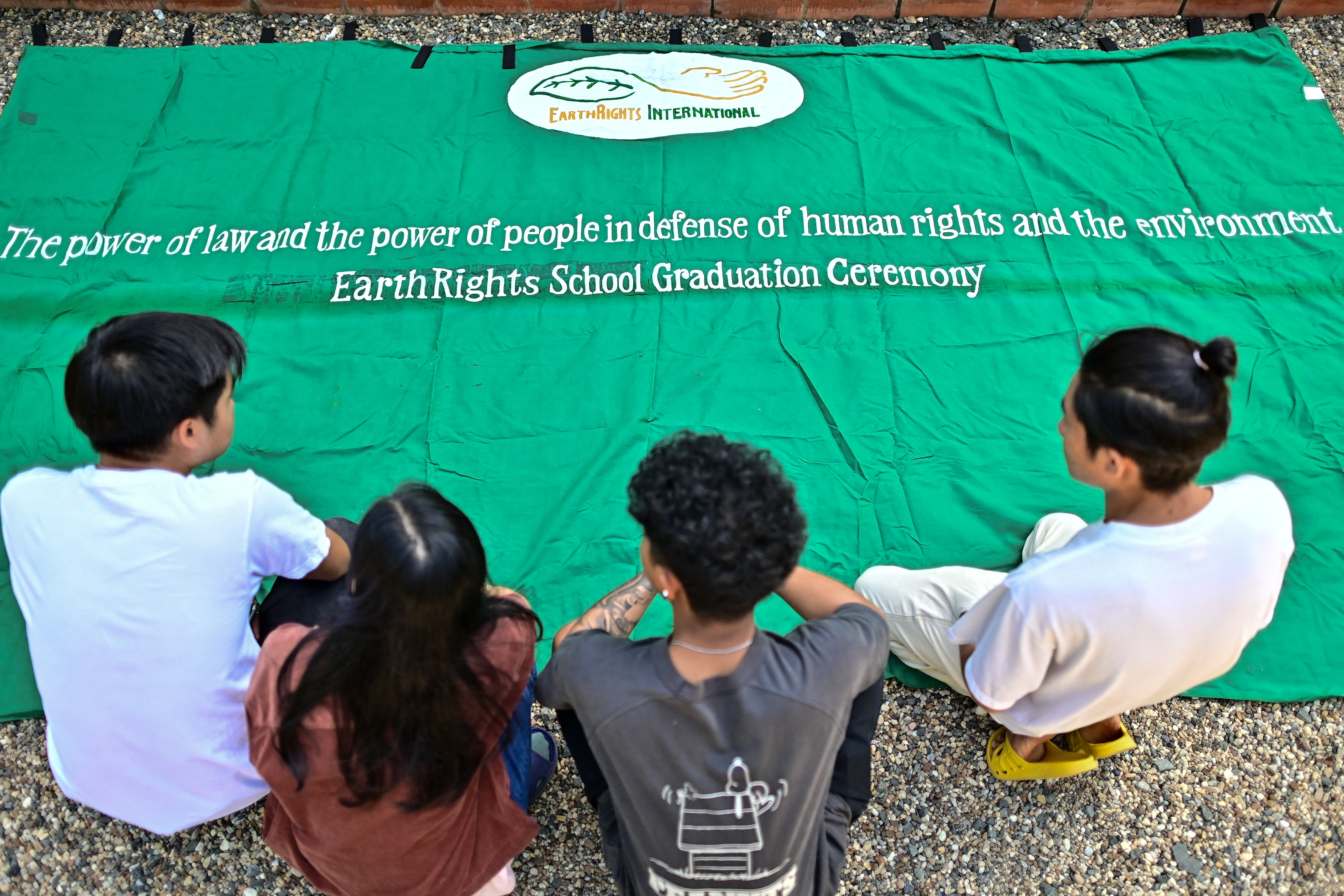This photograph taken on November 21, 2023 shows students preparing a banner for their graduation ceremony at the EarthRights School in Chiang Mai.