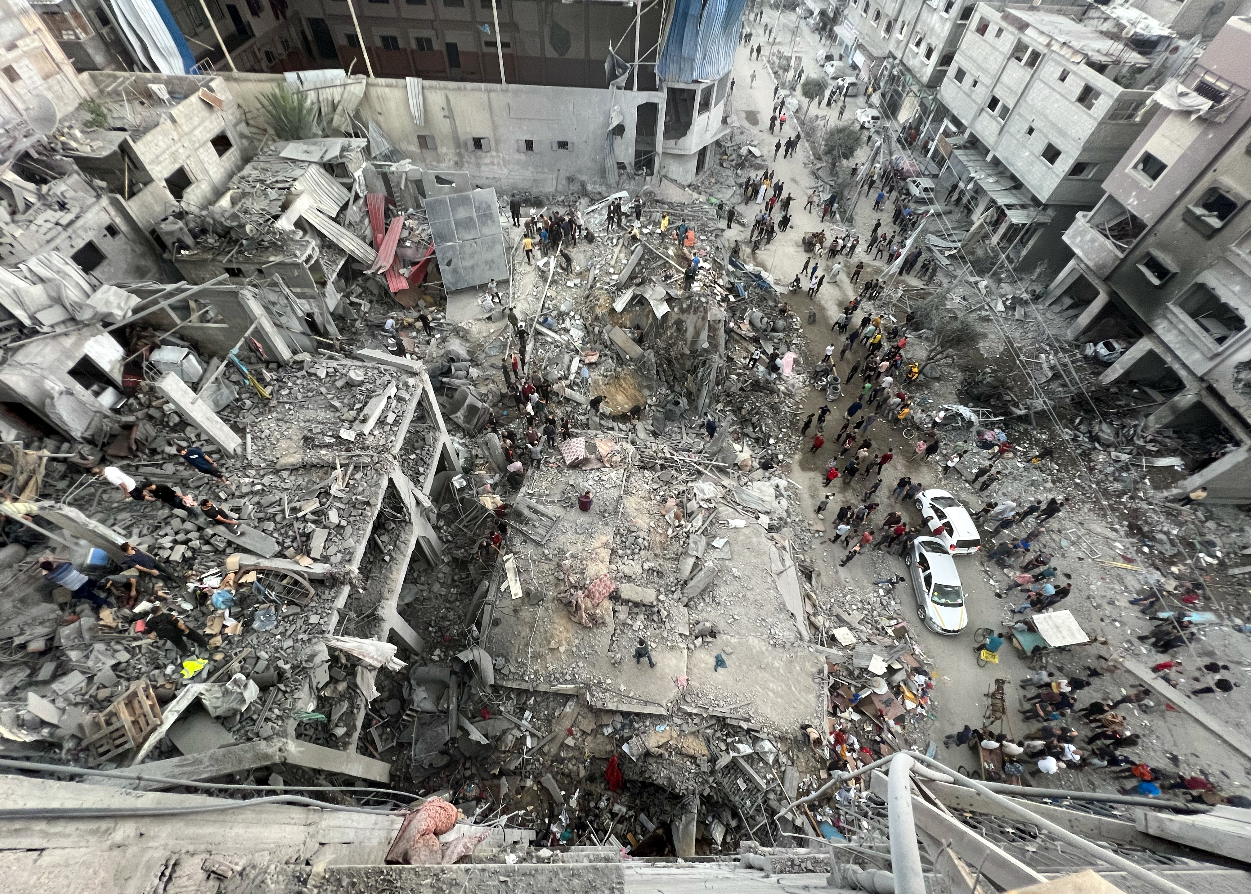 Civil defense teams and civilians conduct a search and rescue operation under the rubble of demolished buildings after Israeli bombardment at Jabalia refugee camp