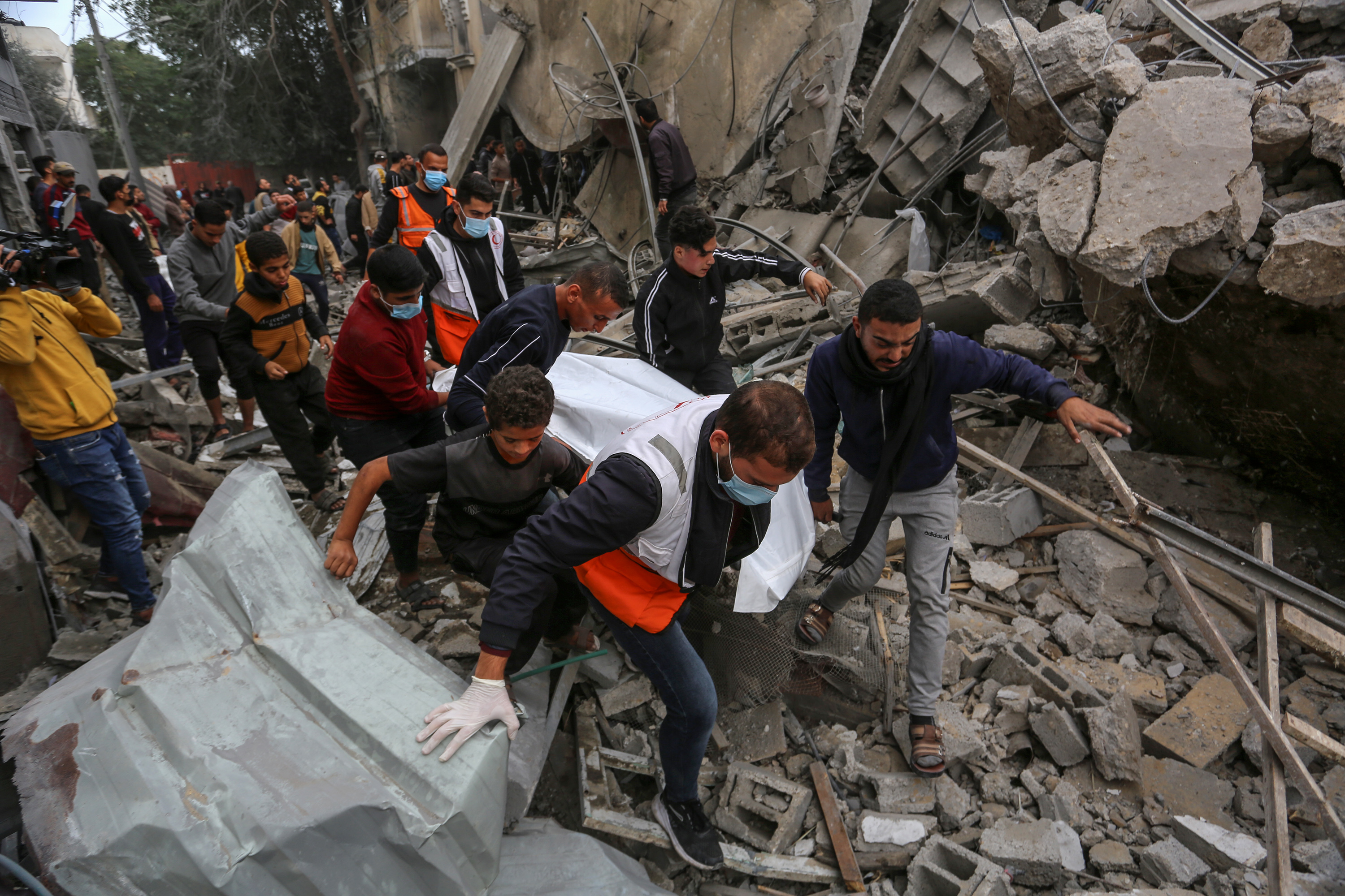 A lifeless body is pulled out among the rubble of the destroyed building as civil defense team and civilians make search and rescue efforts following an Israeli attack on a house belonging to the Oveyda family on the 47th day of the conflict in Rafah, Gaza.