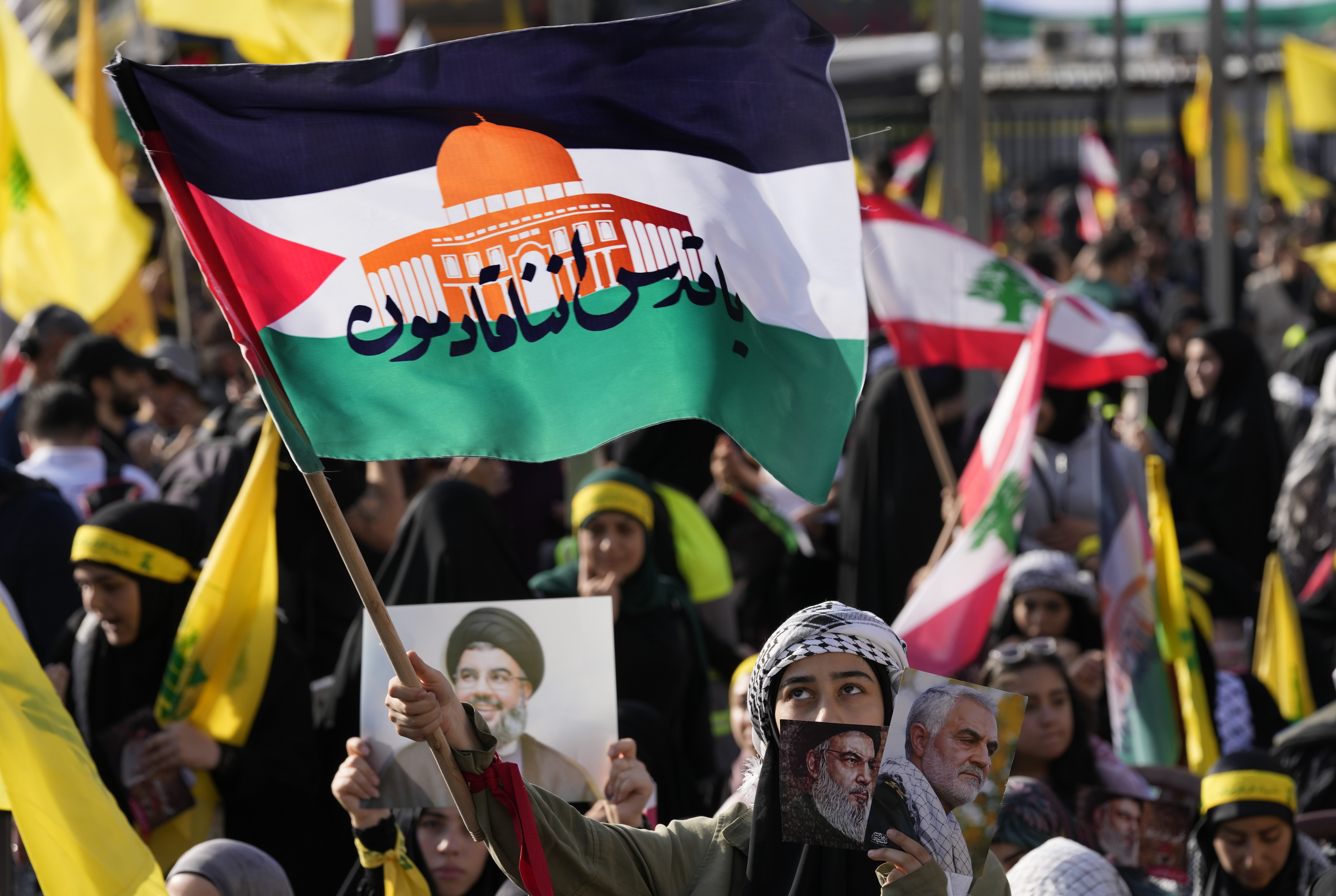 A supporter of the Iranian-backed Hezbollah group waves a Palestinian flag with Arabic words that read: "Jerusalem we are coming," as she waits the speech of Hezbollah leader Sayyed Hassan Nasrallah during a rally to commemorate Hezbollah fighters who were killed in South Lebanon last few weeks while fighting against the Israeli forces, in Beirut, Lebanon.