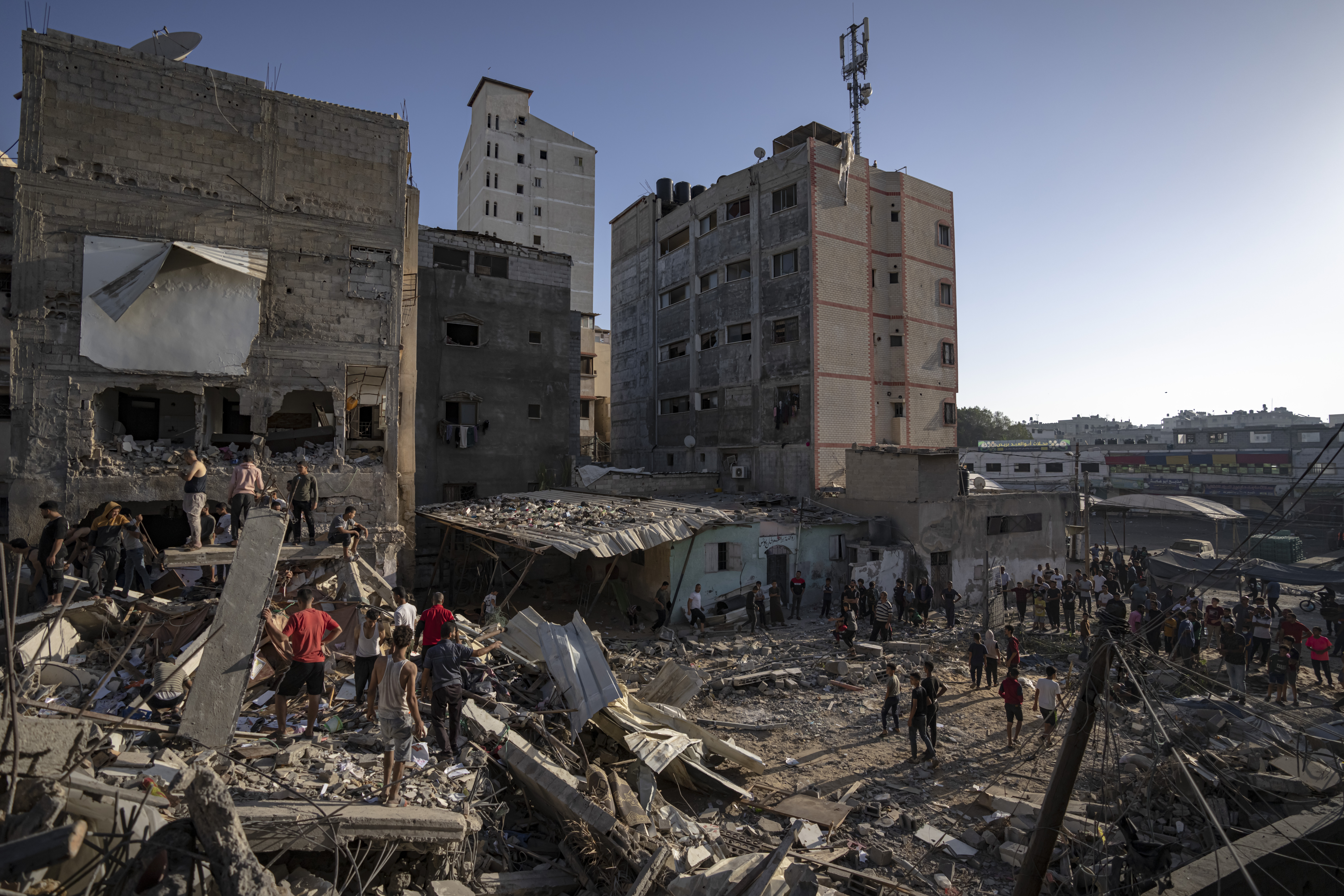 Palestinians look at the destruction after Israeli strikes on the Gaza Strip in Khan Younis